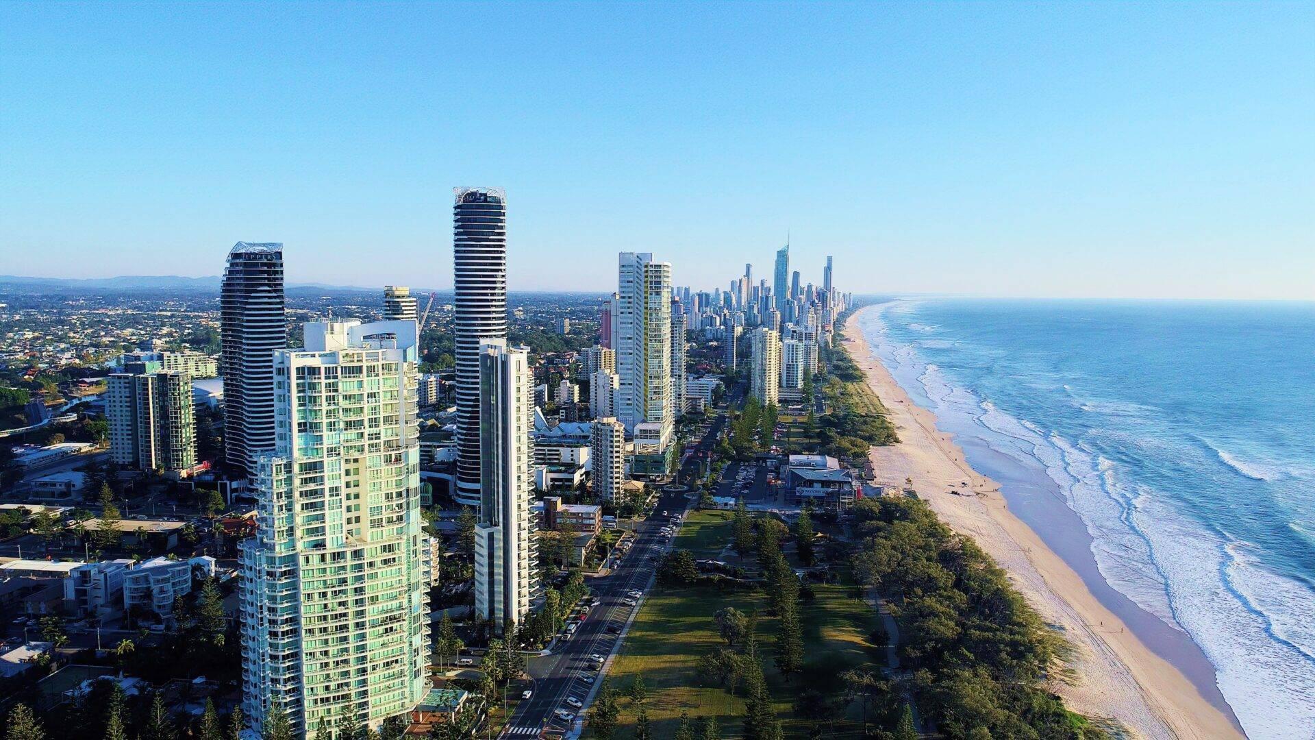 Vista aérea de una estación costera con rascacielos, playa de arena y océano azul