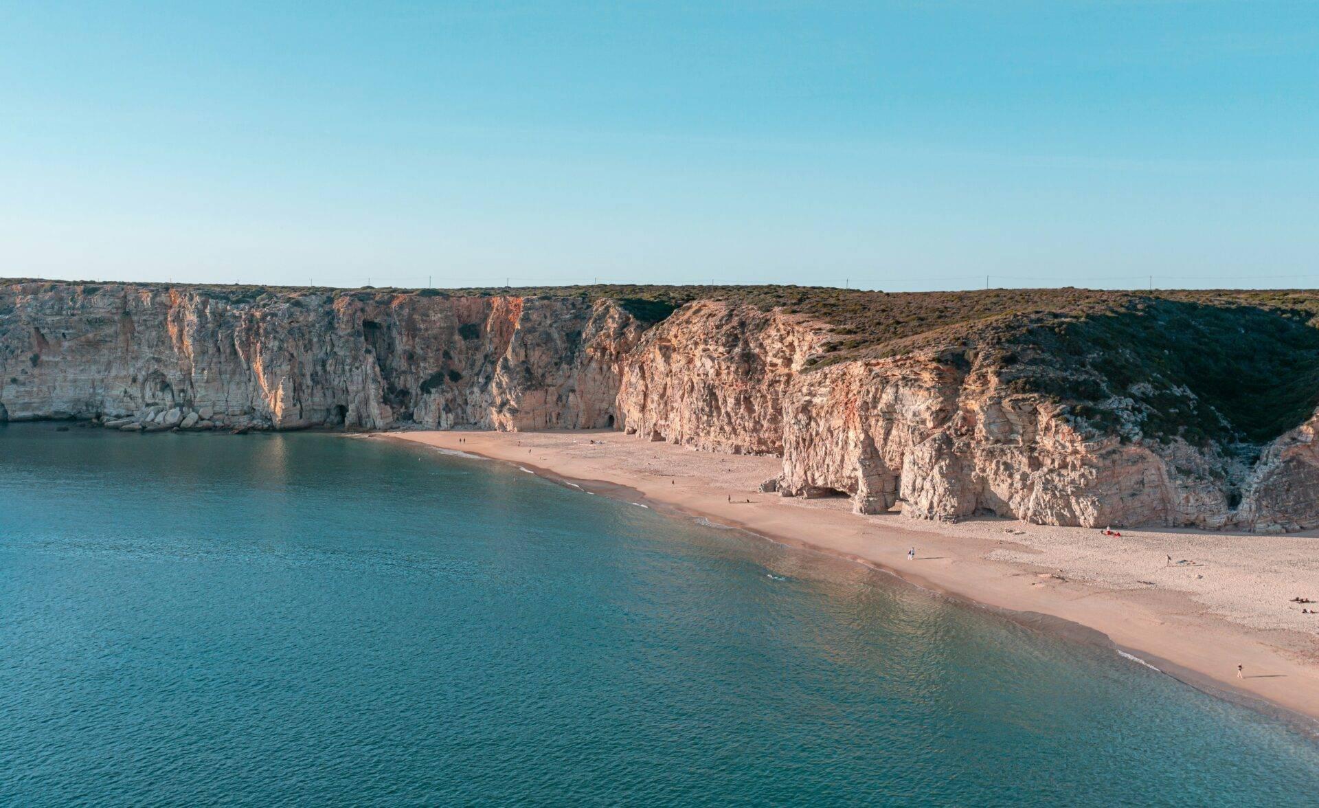 Una spiaggia di sabbia fine incorniciata da imponenti scogliere calcaree bianche che dominano un mare turchese cristallino