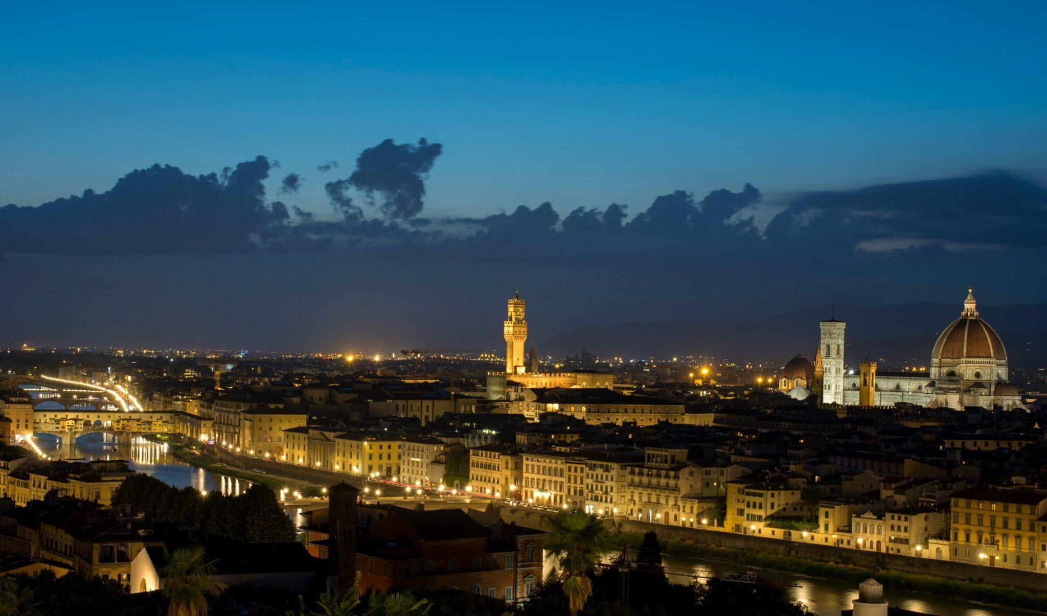 Vue nocturne d’une ville historique illuminée avec dôme Renaissance, fleuve et architecture médiévale