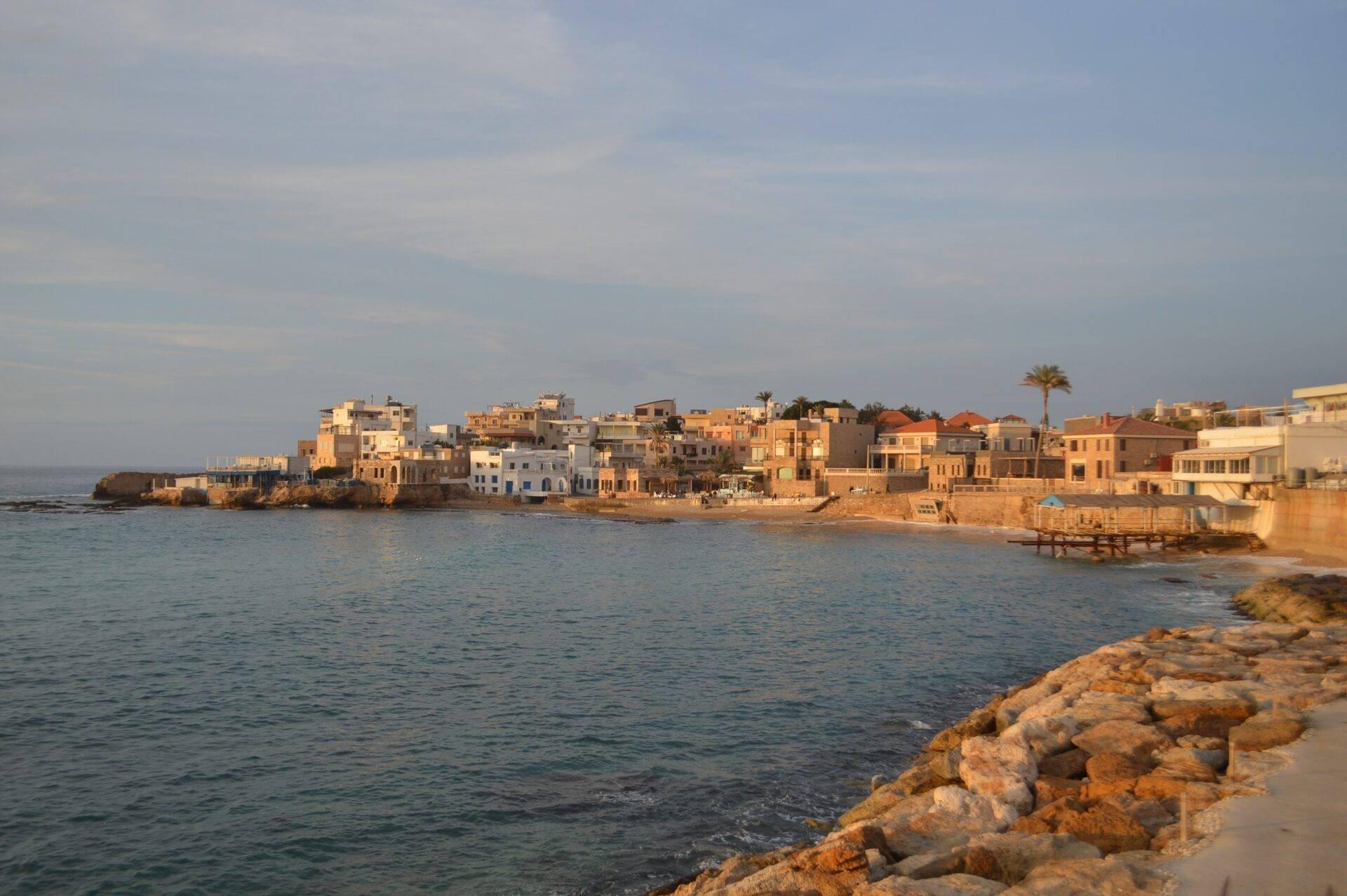 Vue côtière d’un village méditerranéen aux maisons colorées construites directement sur le rivage rocheux