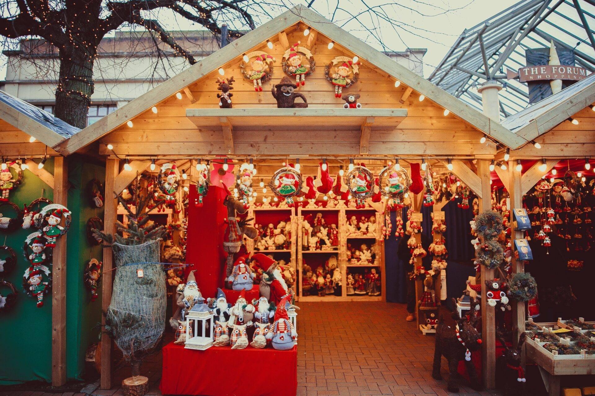Un chalet en bois d’un marché de Noël européen rempli de décorations et figurines festives en rouge et or
