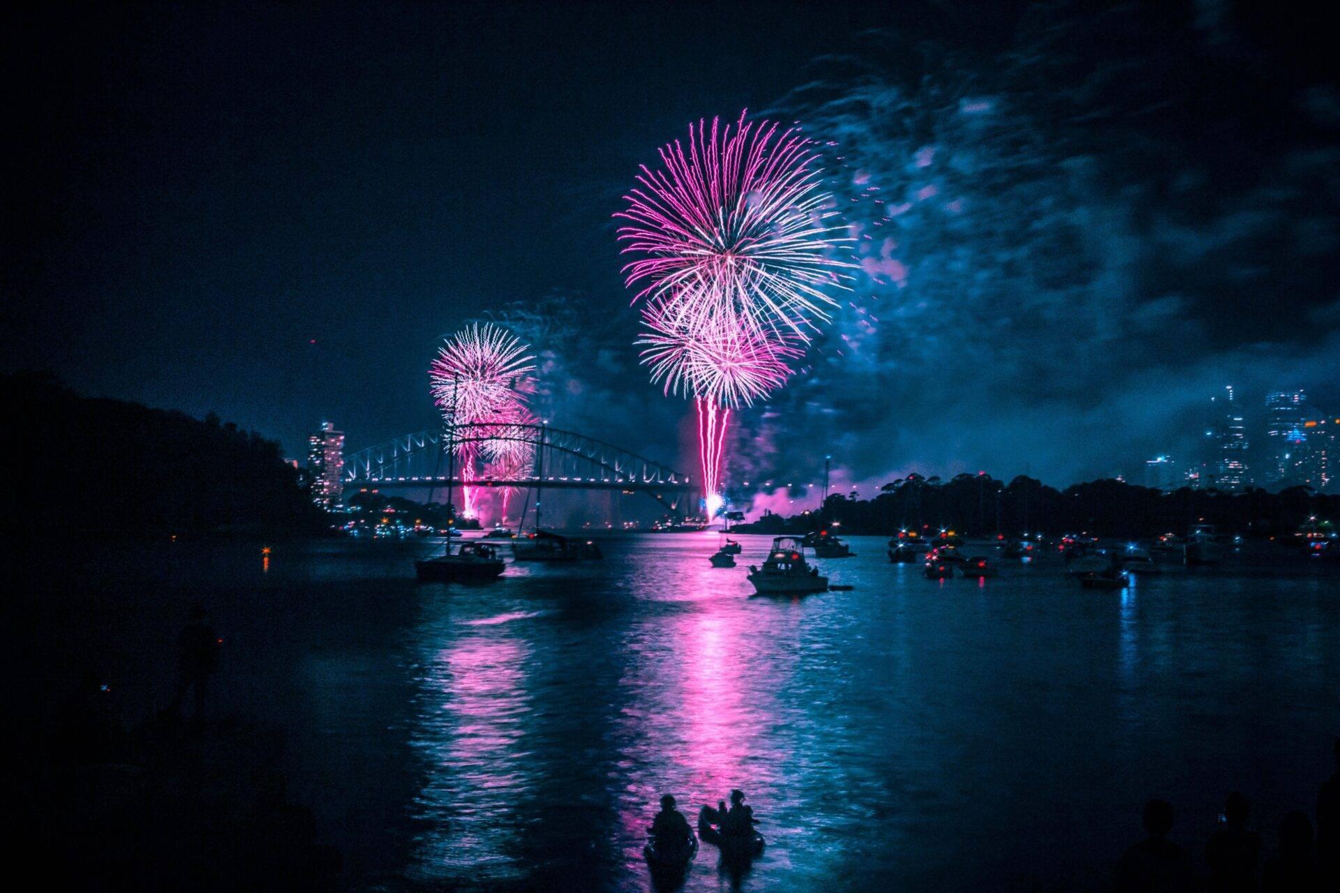 Feux d’artifice explosant au-dessus du port de Sydney avec l’Opera House et le Harbour Bridge la nuit du Nouvel An