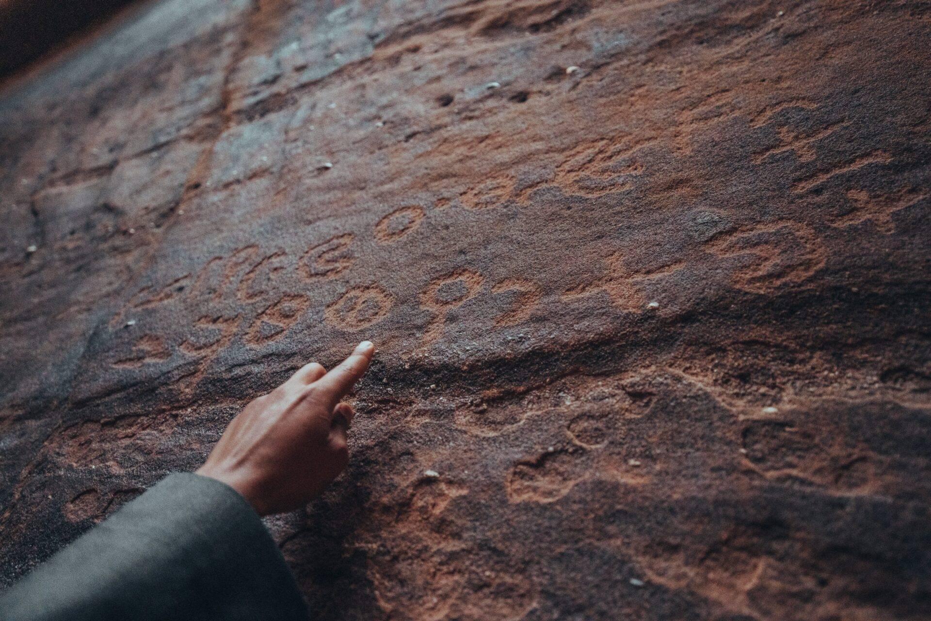 La main d’un enfant touche la surface rugueuse d’une ancienne brique rougeâtre d’une structure architecturale historique