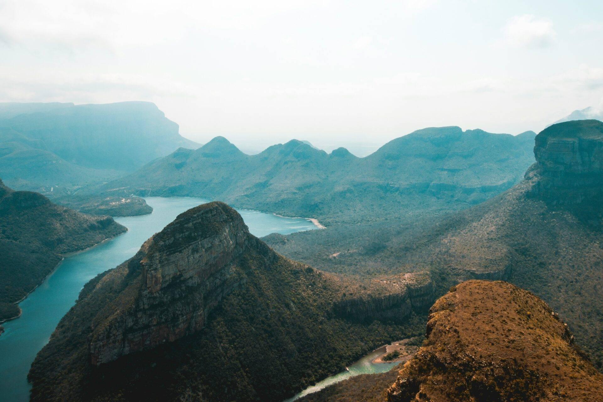 Vista aerea di laghi turchesi circondati da montagne boscose e formazioni rocciose scoscese