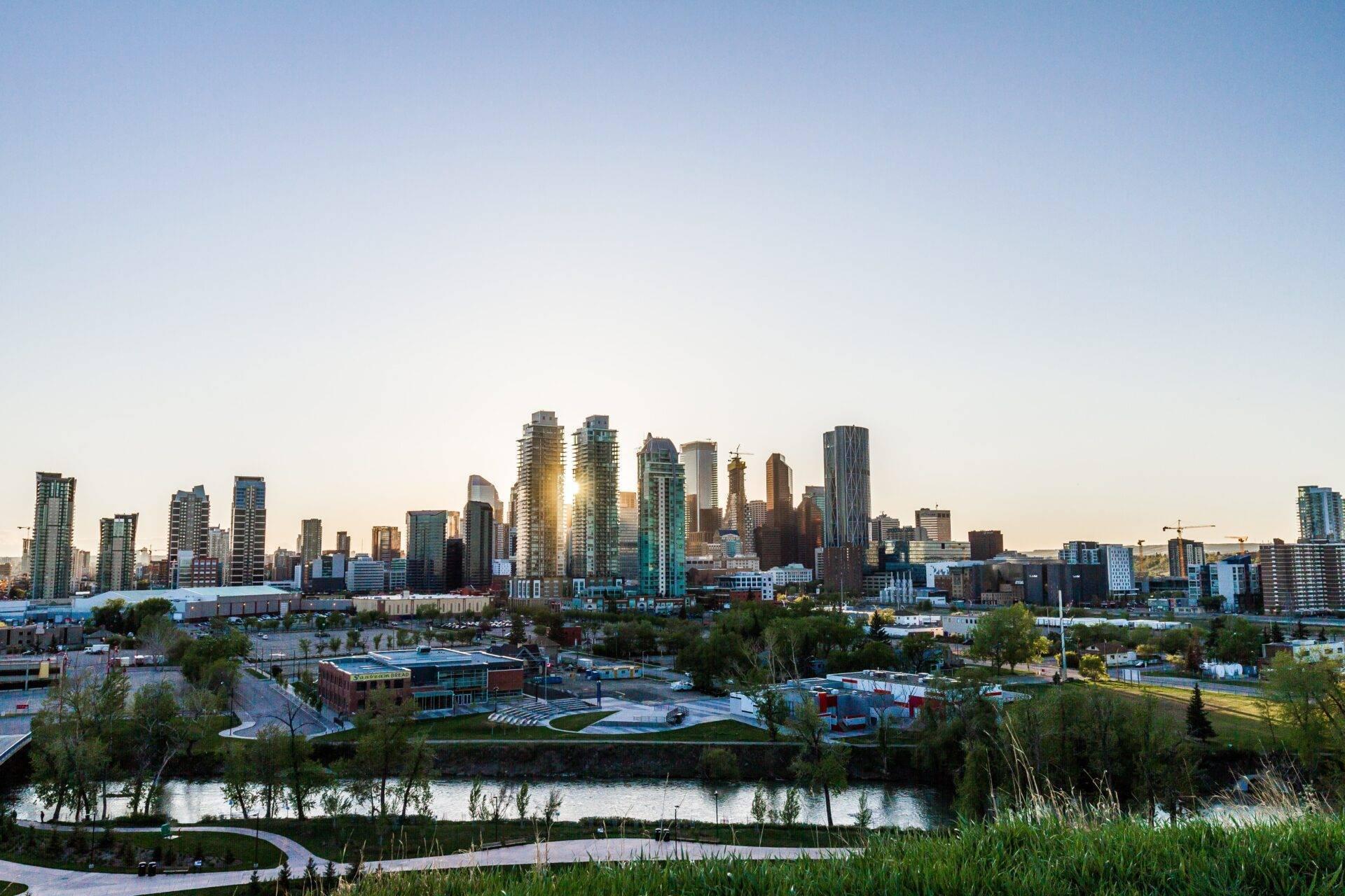 Skyline d’une grande ville canadienne au coucher de soleil avec gratte-ciel modernes et rivière en premier plan