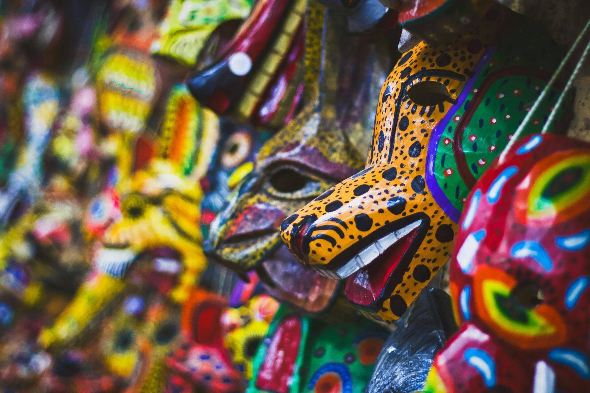 Masques colorés traditionnels guatémaltèques exposés avec motifs géométriques et teintes vives typiques de l’artisanat local