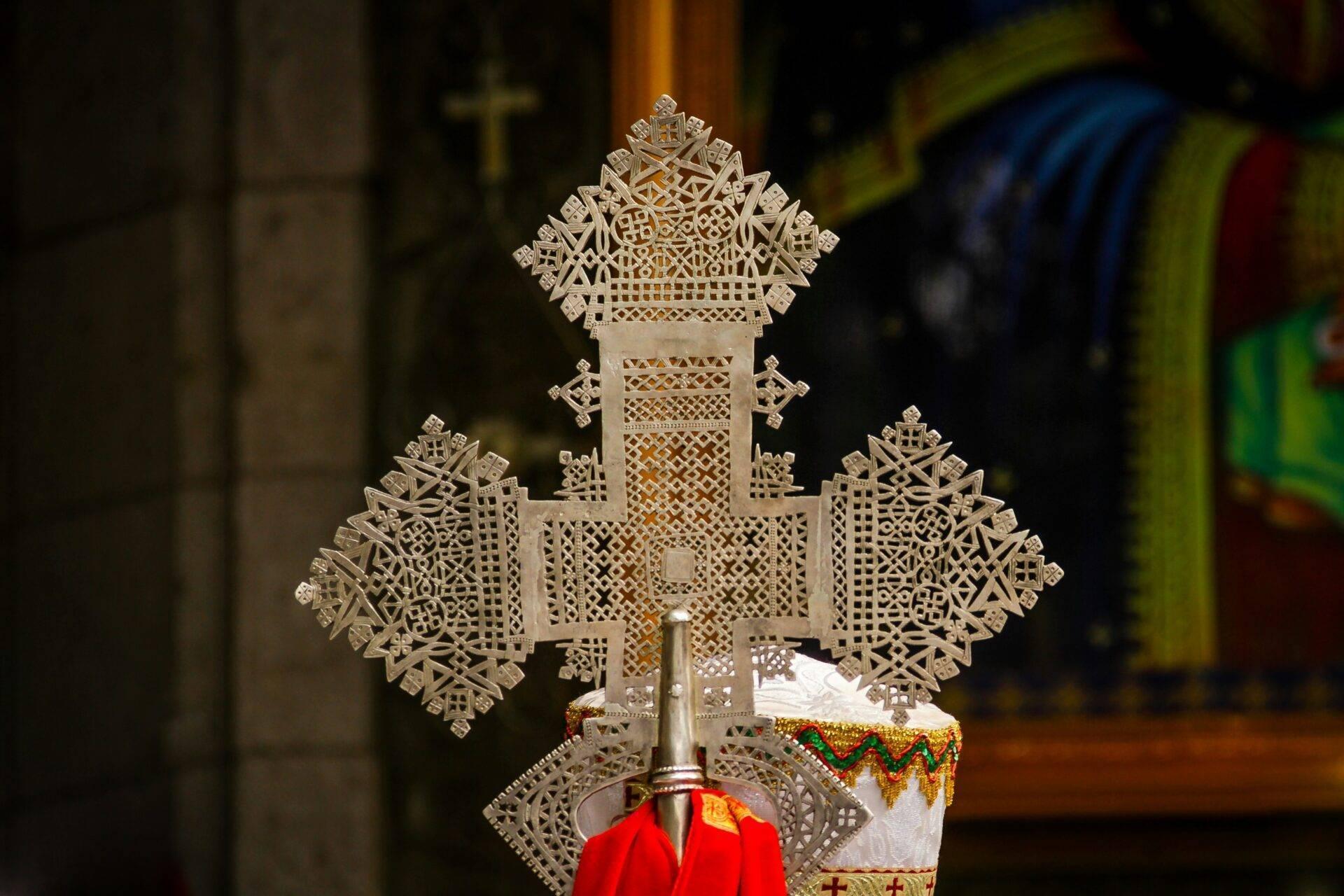 Kunstvolles durchbrochenes Metallkreuz in einem äthiopisch-orthodoxen Tempel mit rotem Stoff und goldenen Verzierungen