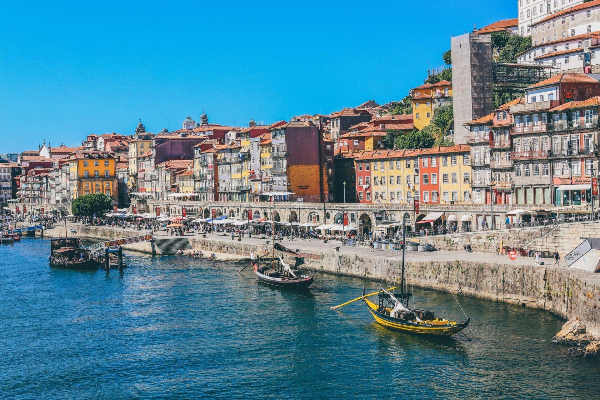 Vista panoramica di una città portuale con edifici colorati, barche tradizionali e architettura storica sul lungofiume