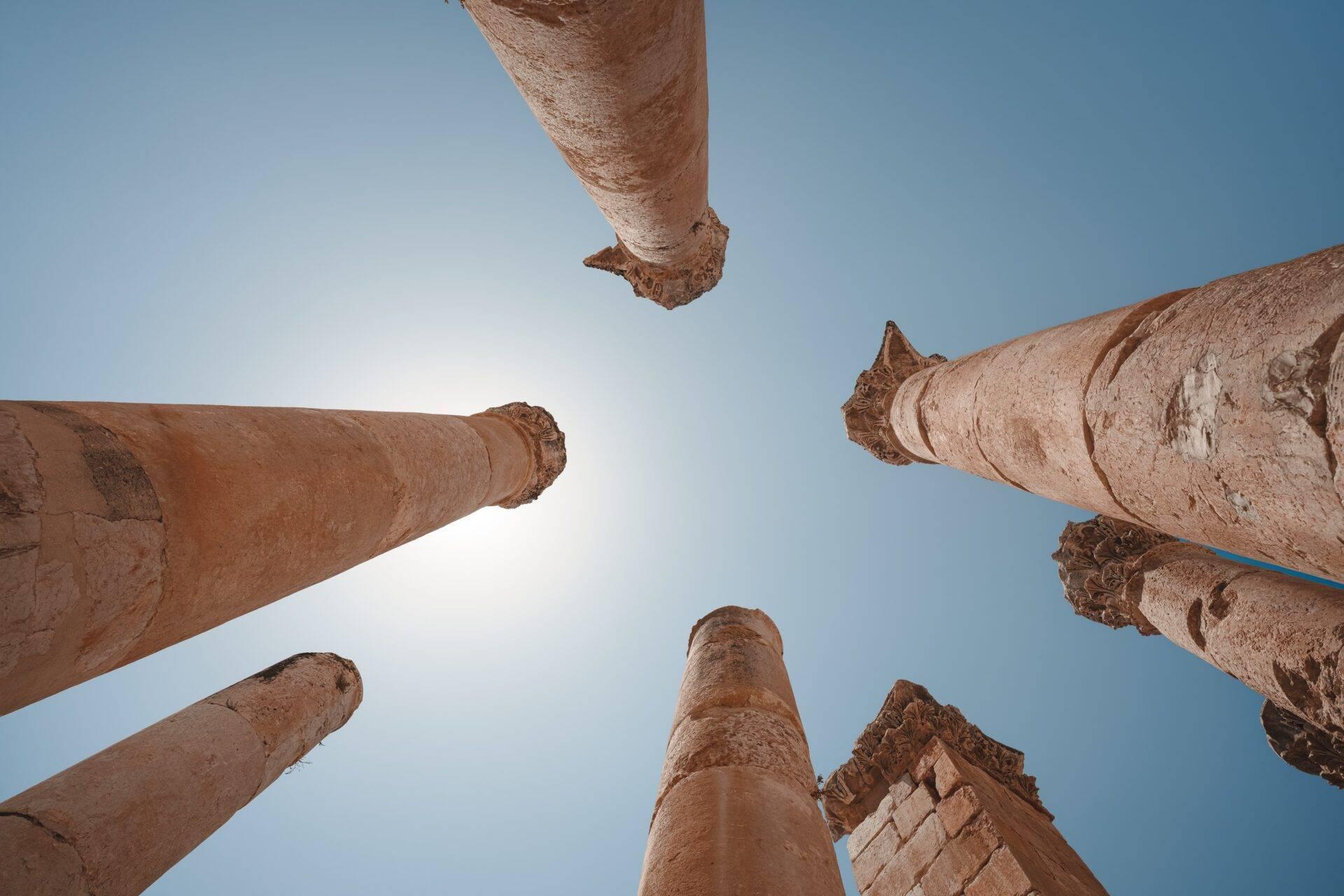 Vista dall’alto di colonne in pietra antiche e monumentali su uno sfondo di cielo azzurro terso