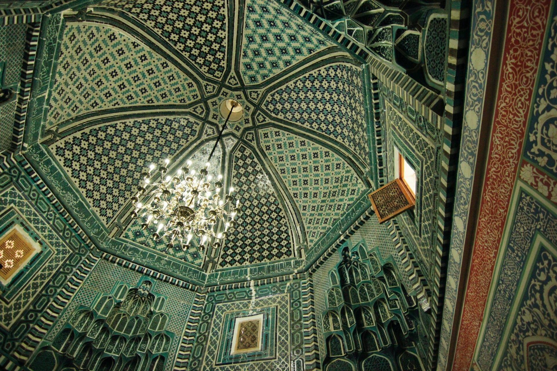 Vue aérienne de l’intérieur d’une mosquée avec plafond octogonal orné, zellige turquoise et lustre central
