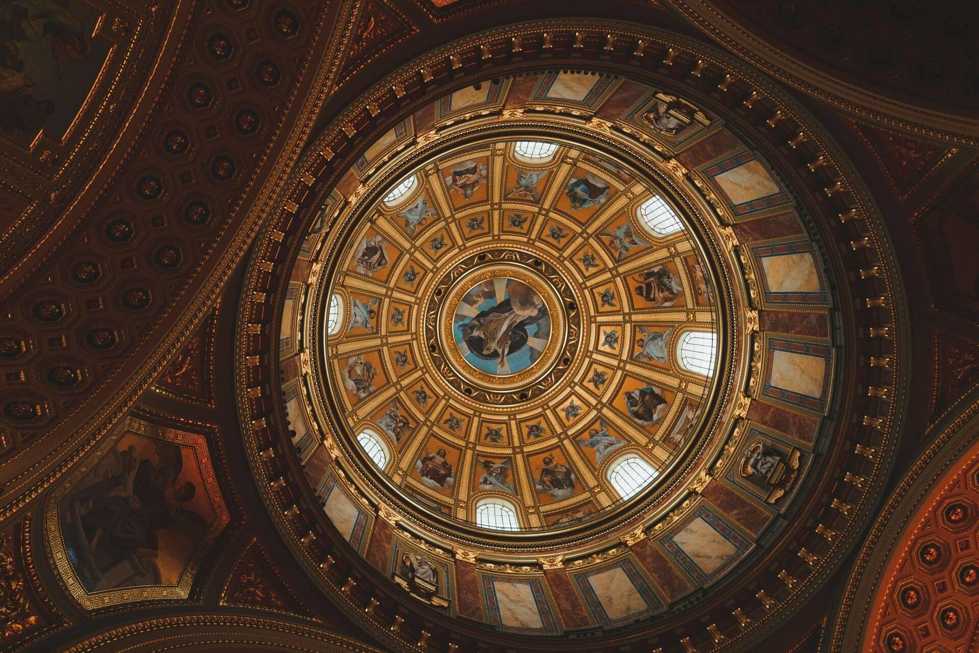 Vista dall’alto di una cupola circolare riccamente ornata con affreschi, dorature e oculo luminoso in architettura neoclassica