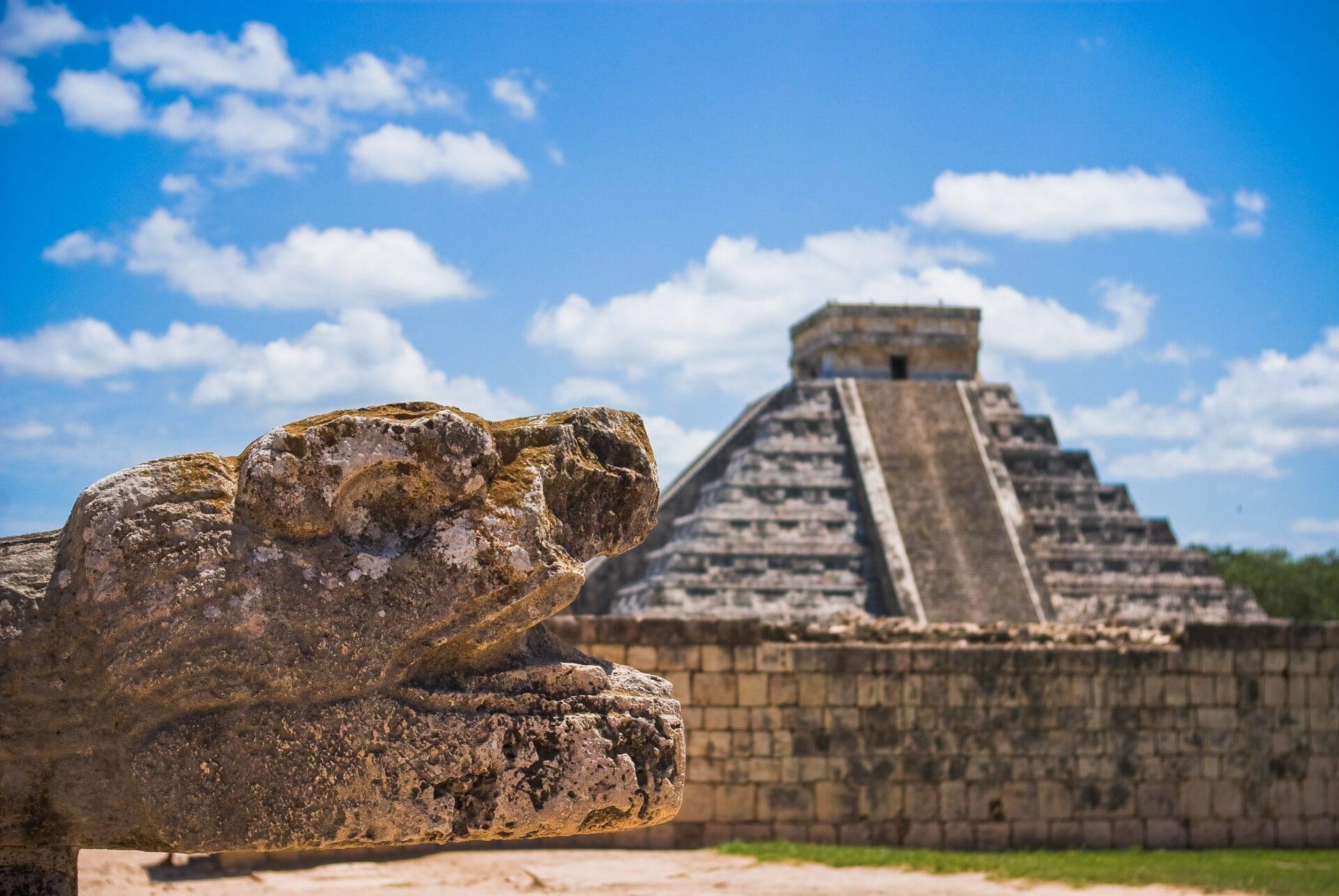 Voyageur avec sac à dos devant un temple maya au Mexique sous ciel bleu