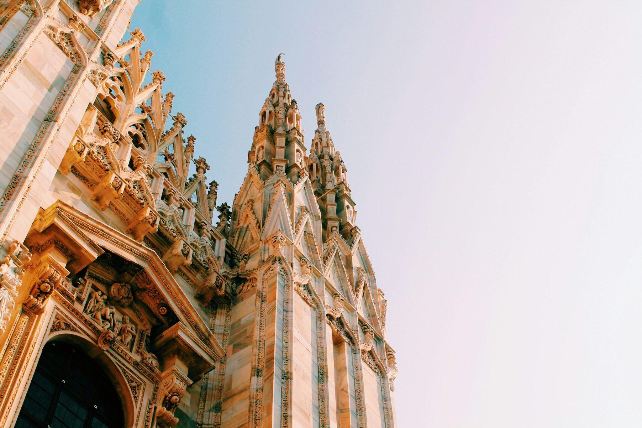 Détail architectural d’une cathédrale gothique avec façade ornementée et spires pointues sous ciel dégagé