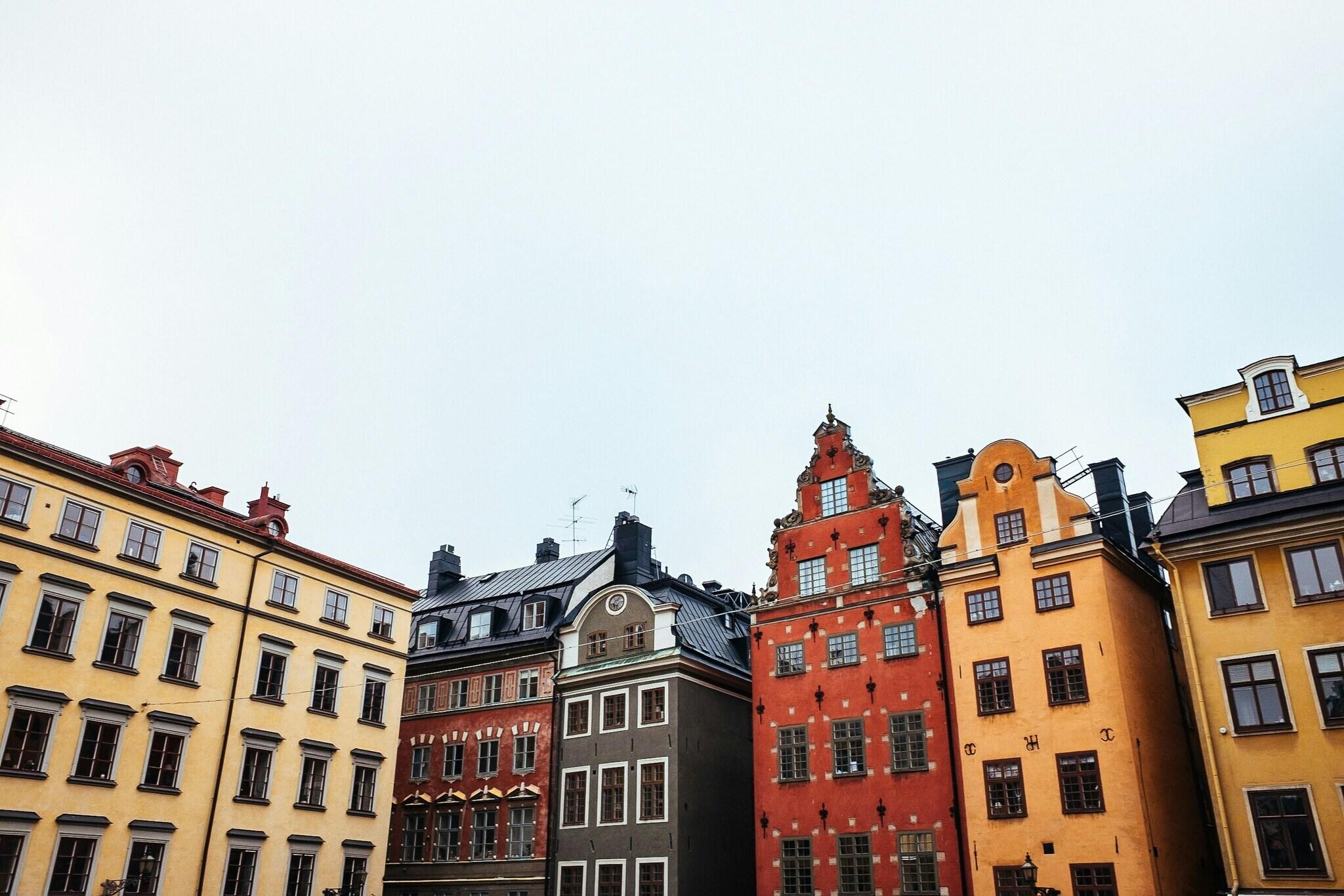 Facciate colorate di storici edifici nordici allineati su una piazza acciottolata sotto un cielo terso