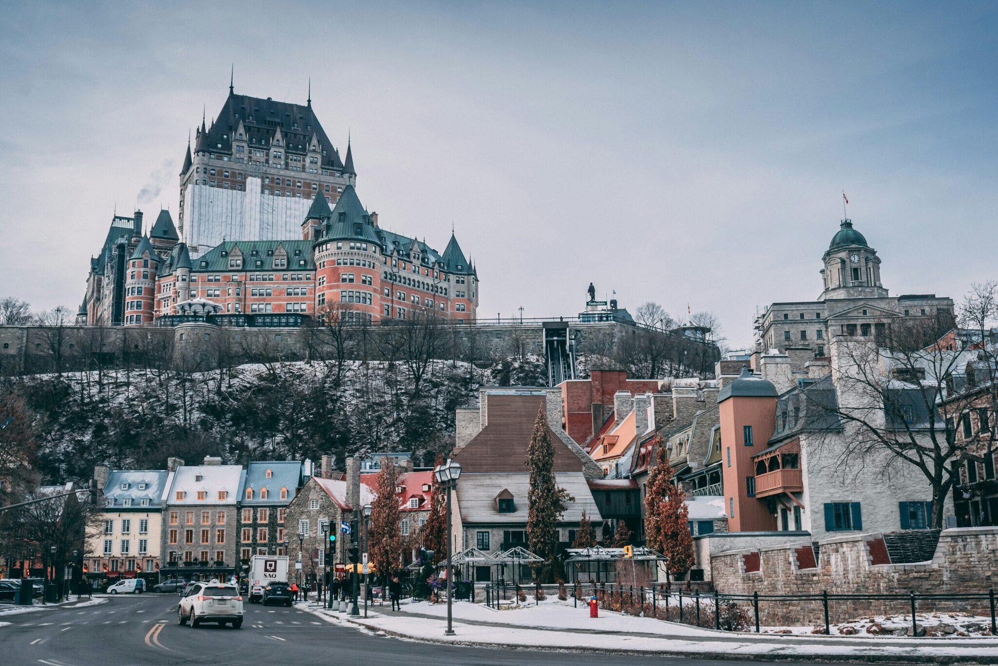 Vue hivernale d’une ville historique avec château imposant en arrière-plan et architecture européenne colorée