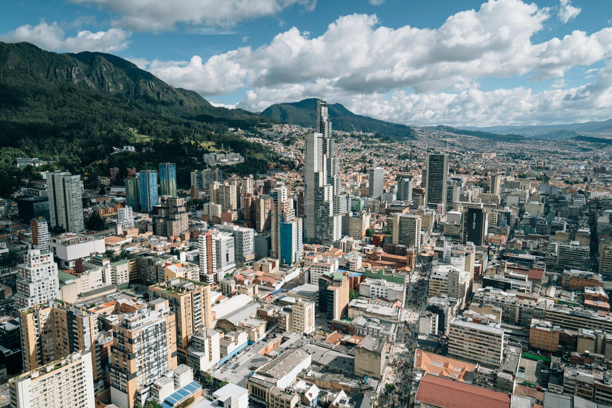 Vue aérienne d’une grande ville andine encadrée de montagnes verdoyantes sous un ciel dégagé