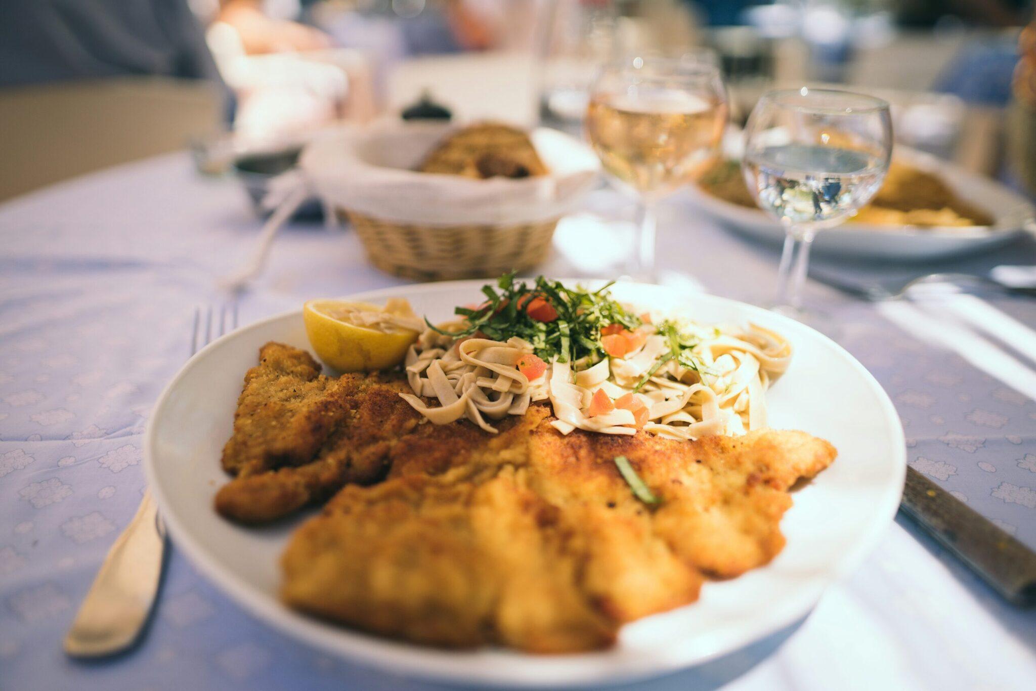 Une assiette de fruits de mer avec pâtes et crevettes dorées servie lors d’un repas en terrasse