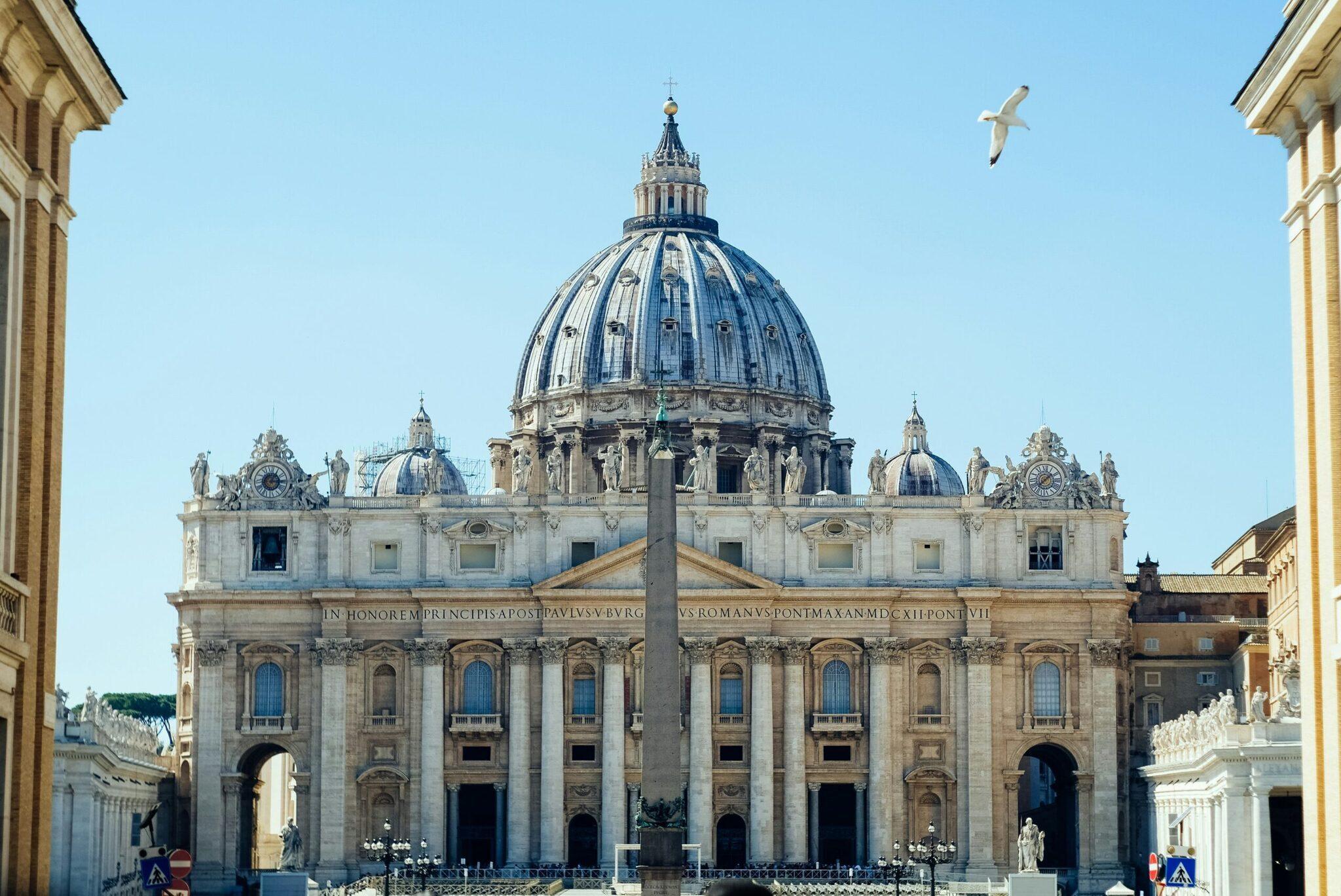 Basilique majeure avec dôme Renaissance central, colonnade et obelisque, sous ciel dégagé