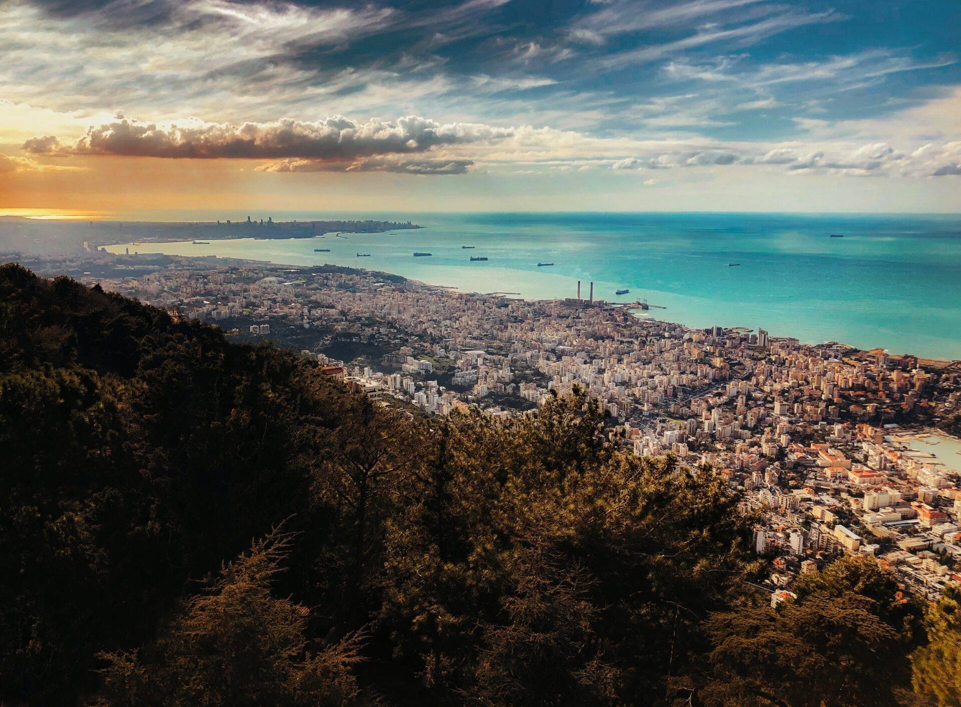 Vue panoramique d’une ville côtière méditerranéenne densément construite avec baie turquoise et navires au large