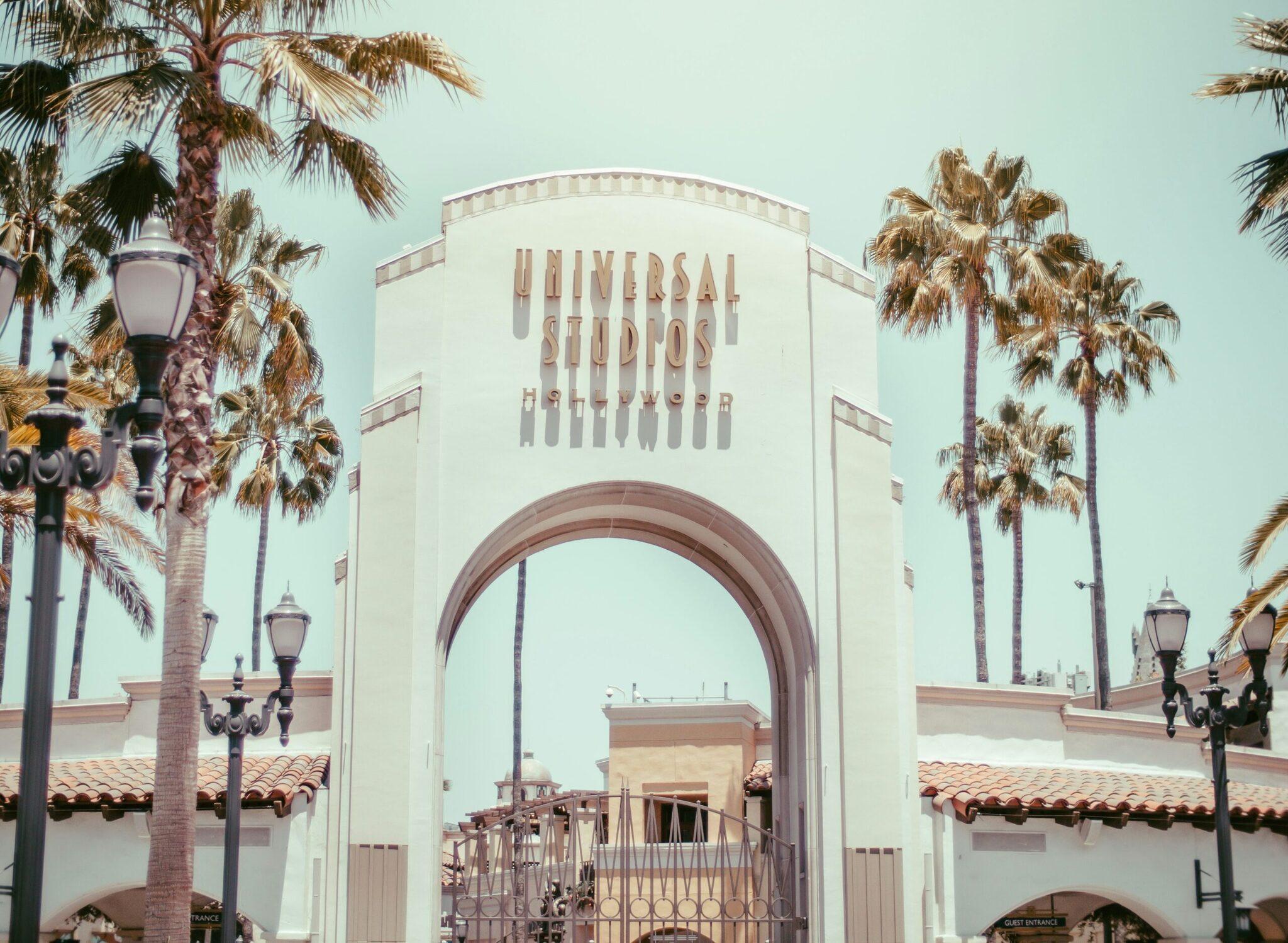 Der berühmte Eingangsbereich der Universal Studios Hollywood mit Palmen unter einem wolkenlosen Himmel