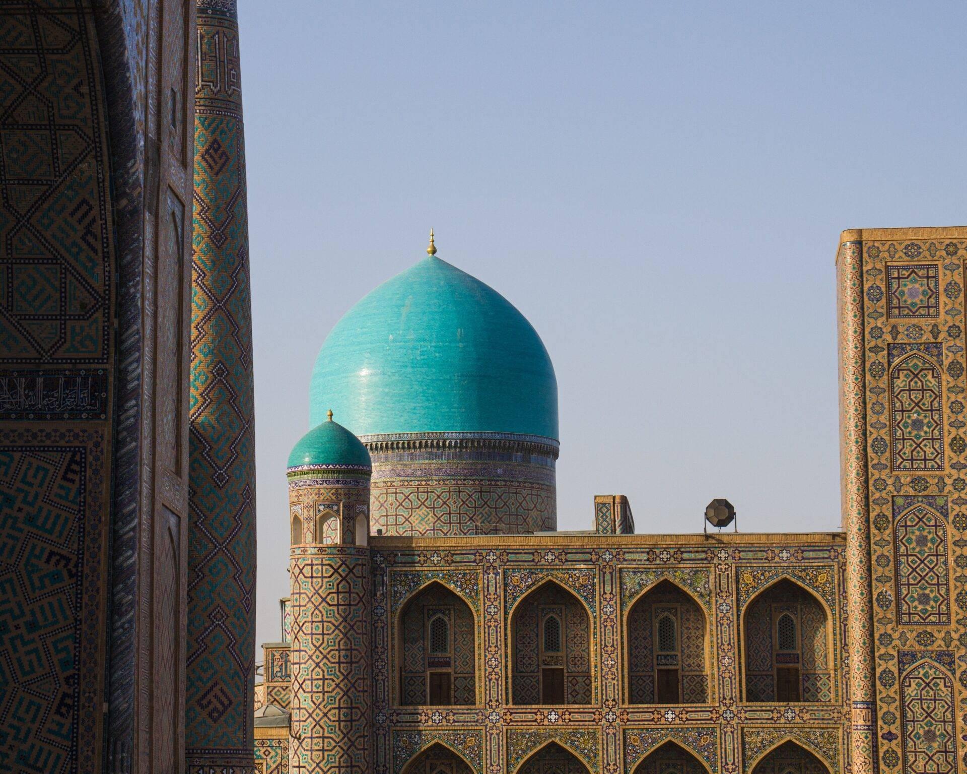 Mosquée islamique ornée de turquoise et d’or avec minarets décorés et dôme bleu ciel