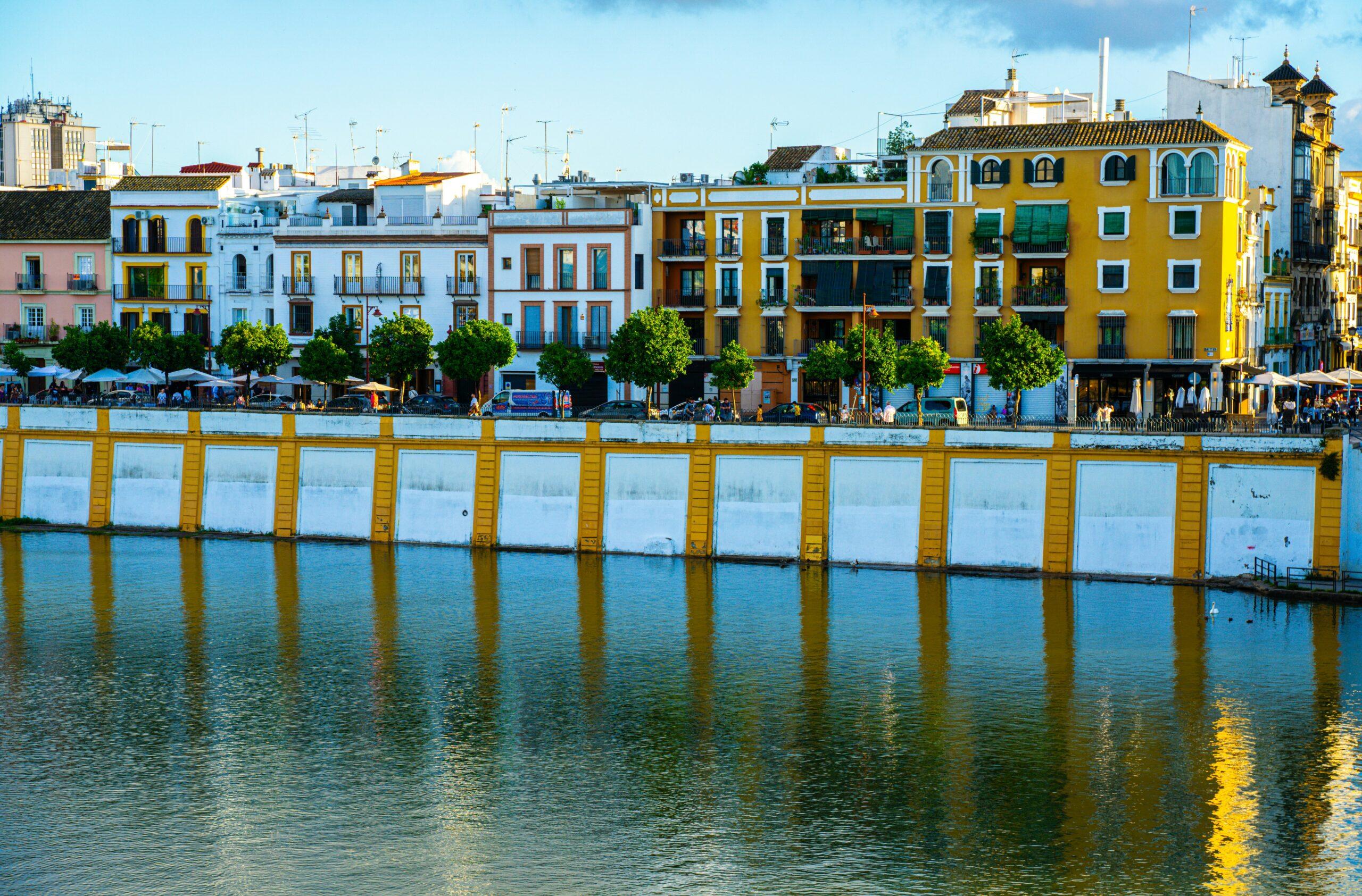 Facciate colorate di edifici storici che si affacciano sul fiume con strutture portuali gialle