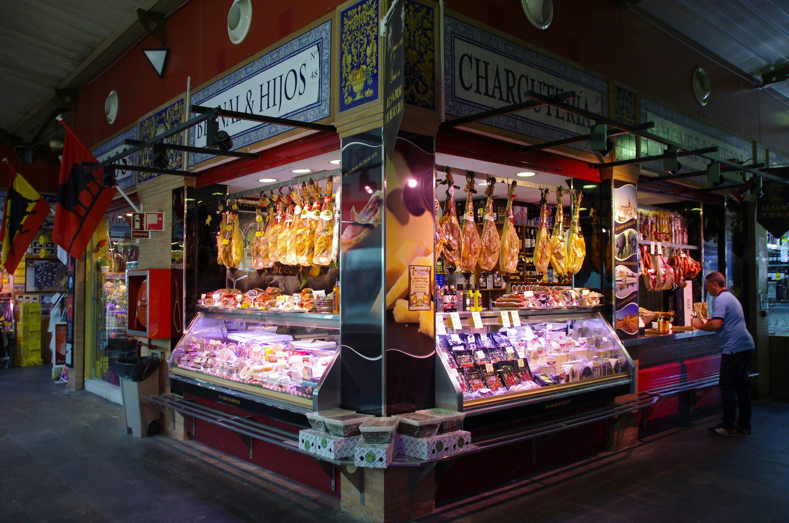 Una salumeria tradizionale spagnola con prosciutti iberici appesi e vetrine refrigerate di prodotti di qualità