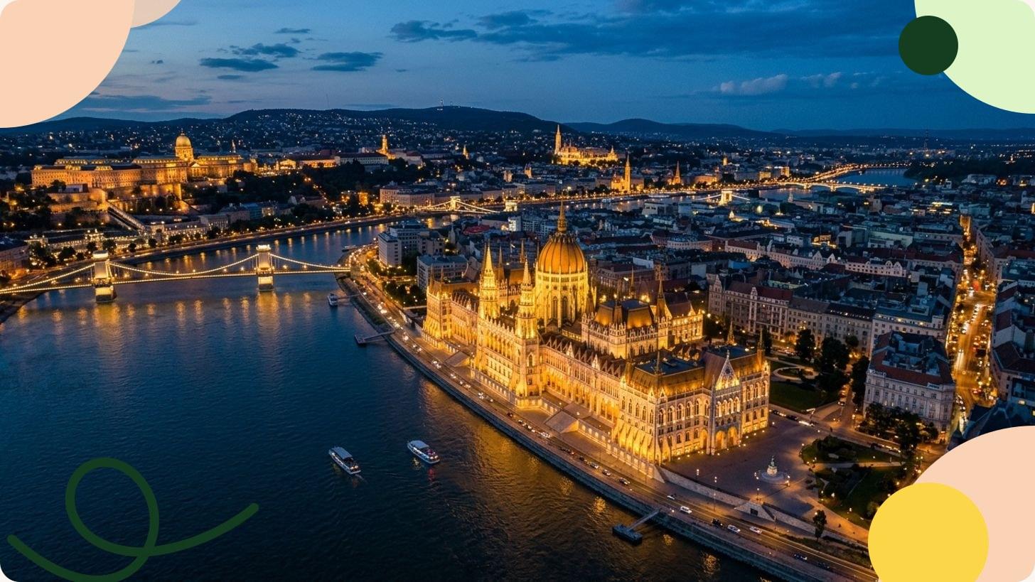 Vista panoramica del Parlamento neogotico di Budapest illuminato al tramonto sulle rive del Danubio