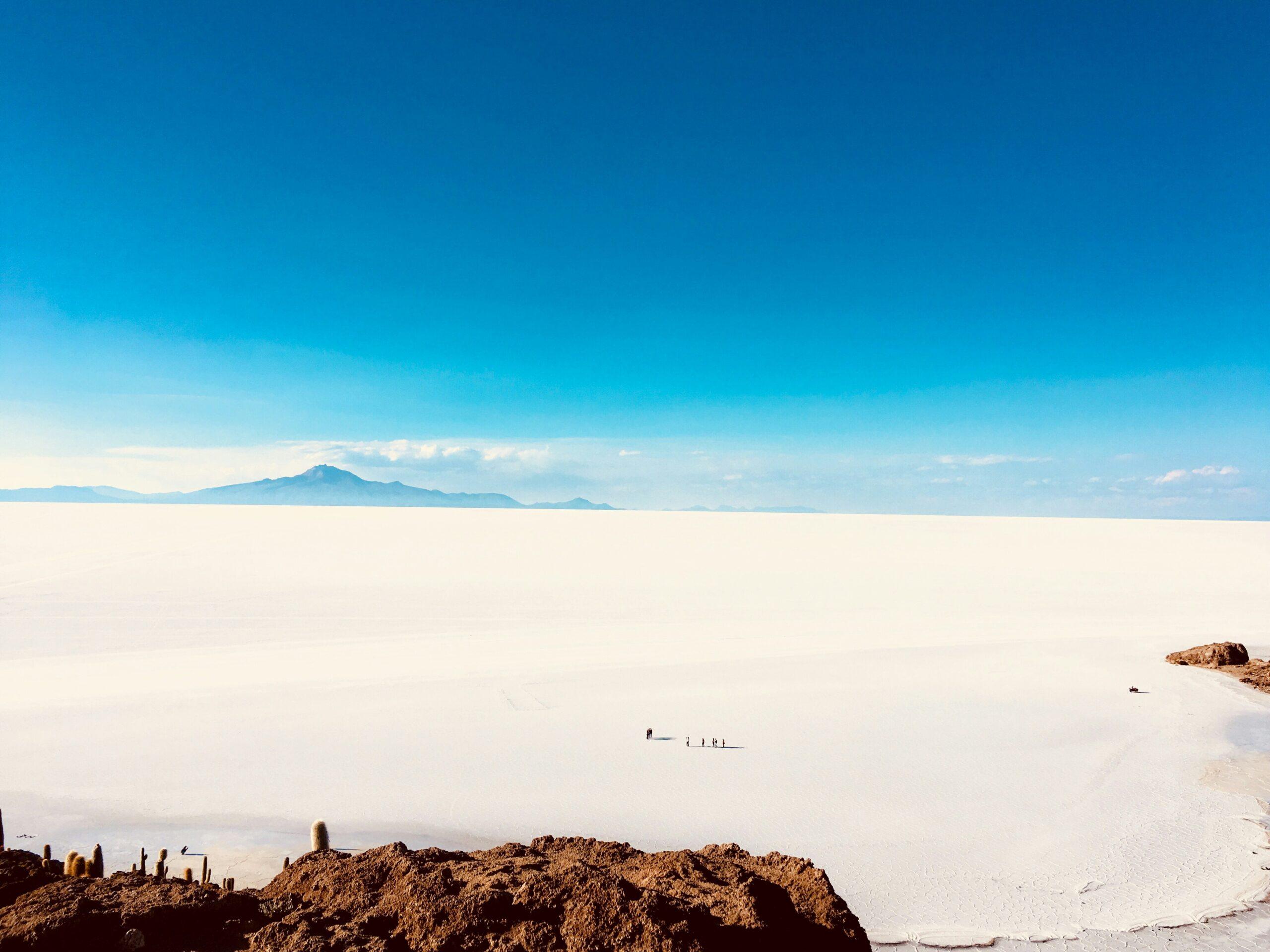 Vue du salar d’Uyuni depuis le sol, dalles hexagonales de sel blanc à perte de vue sous un ciel bleu de l’altiplano bolivien