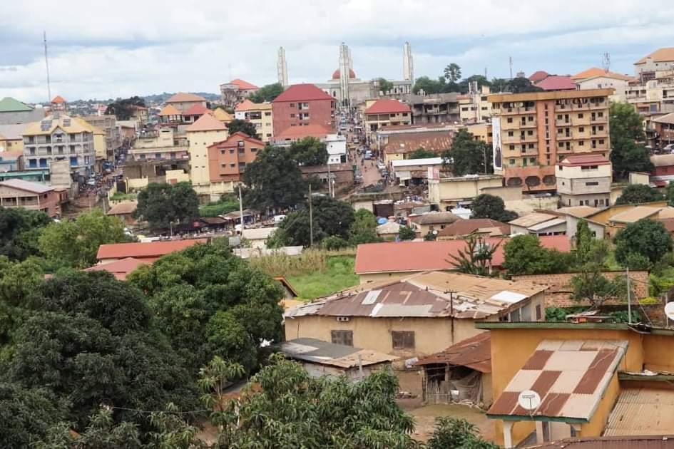 Vue panoramique d’une ville africaine avec bâtiments colorés aux toits rouges et une cathédrale au centre