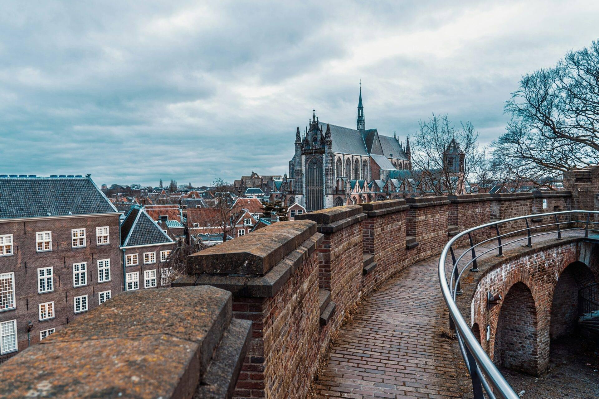 Vue depuis les remparts d’une ville néerlandaise avec église gothique, maisons en brique et ciel nuageux