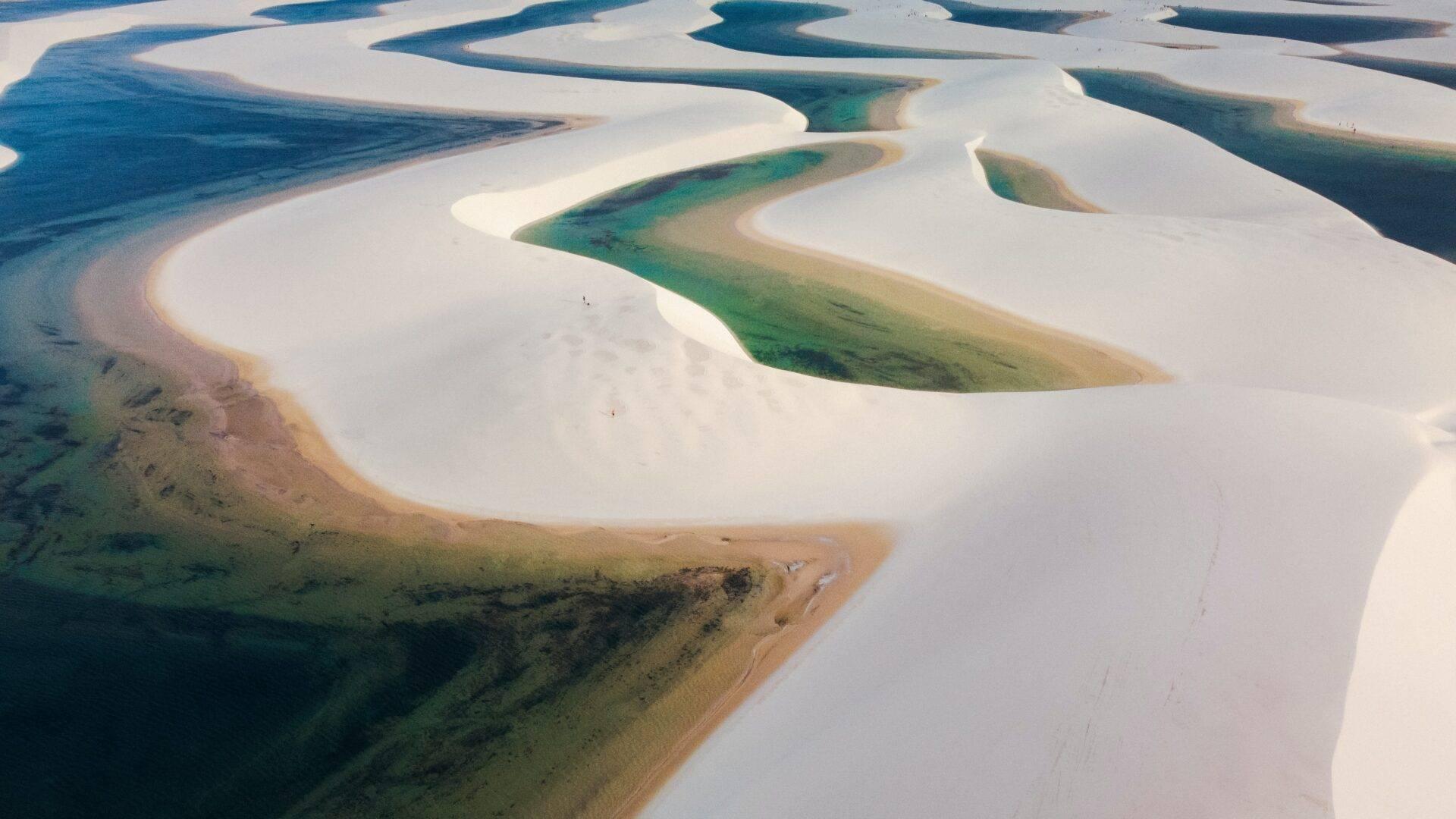 Vue aérienne de lacs avec dunes de sable blanc et eaux turquoise aux teintes bleu-vert dans un paysage désertique côtier