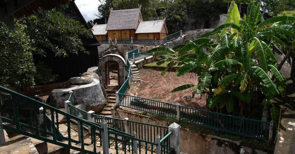 Un complexe touristique tropical avec bâtiments en bois, escaliers en pierre, bassins d’eau et végétation luxuriante