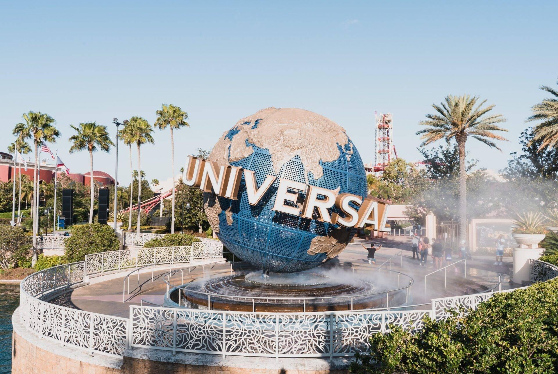 Le globe terrestre bleu et beige du parc à thème Universal Studios avec palmiers et fontaines