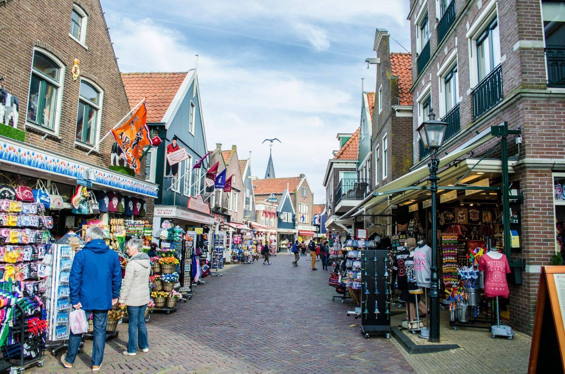 Une rue commerçante typique néerlandaise avec boutiques de souvenirs, maisons traditionnelles aux toits orange et architecture flamande