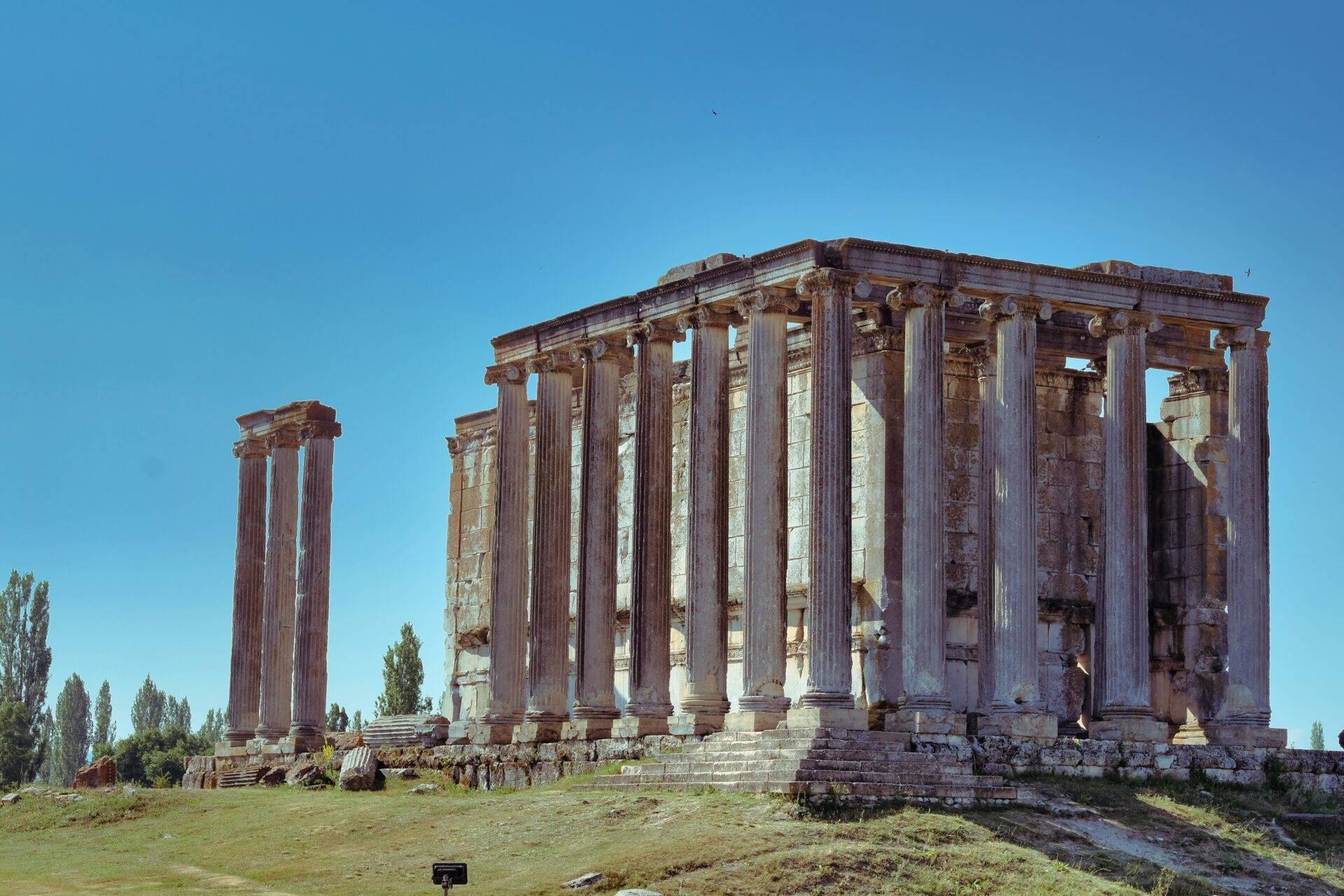 Ruines d’un temple antique avec colonnes corinthiennes imposantes sous un ciel bleu dégagé