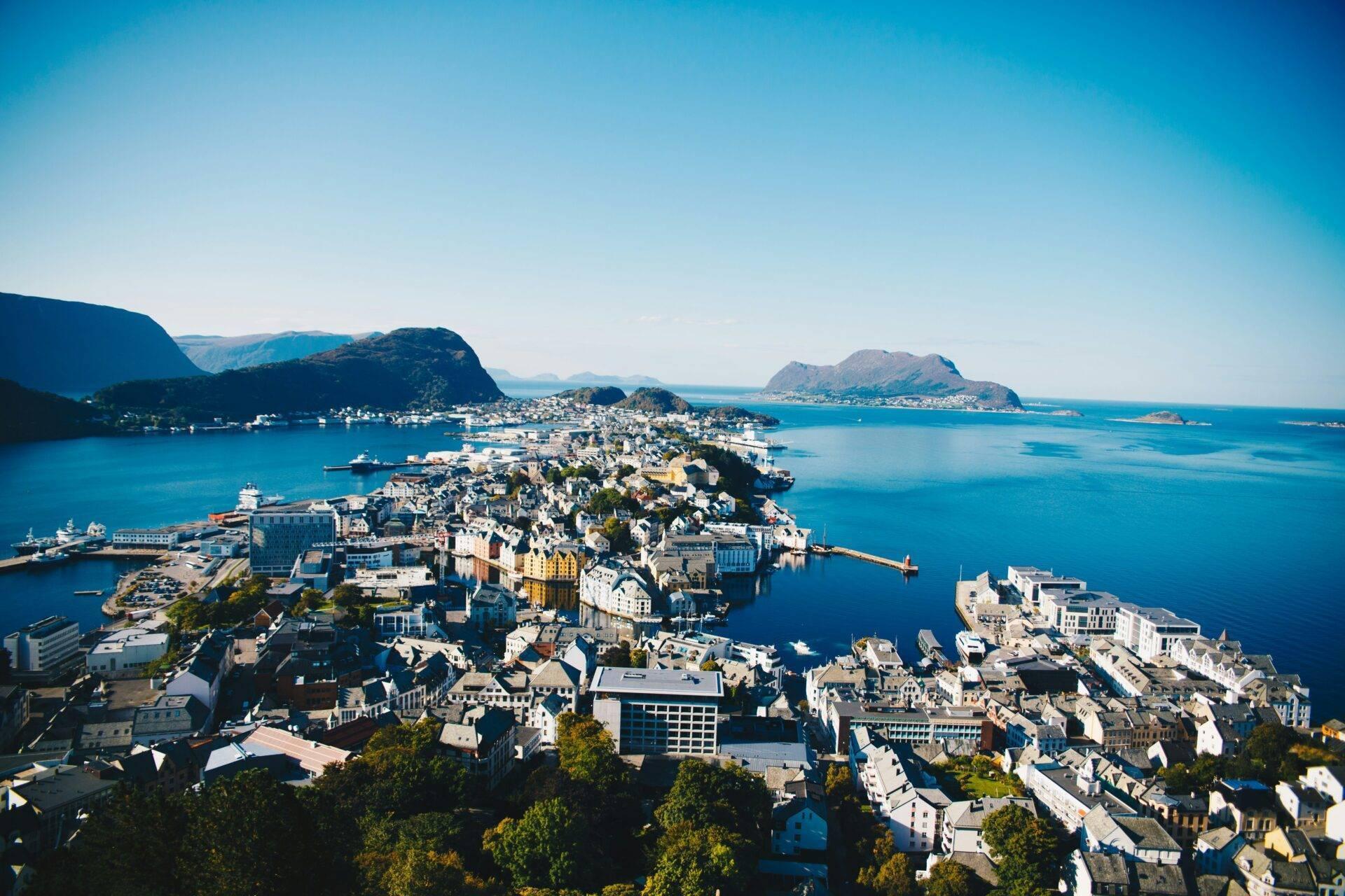 Vue aérienne d’une ville côtière norvégienne densément construite sur une presqu’île rocheuse entourée de fjords bleus