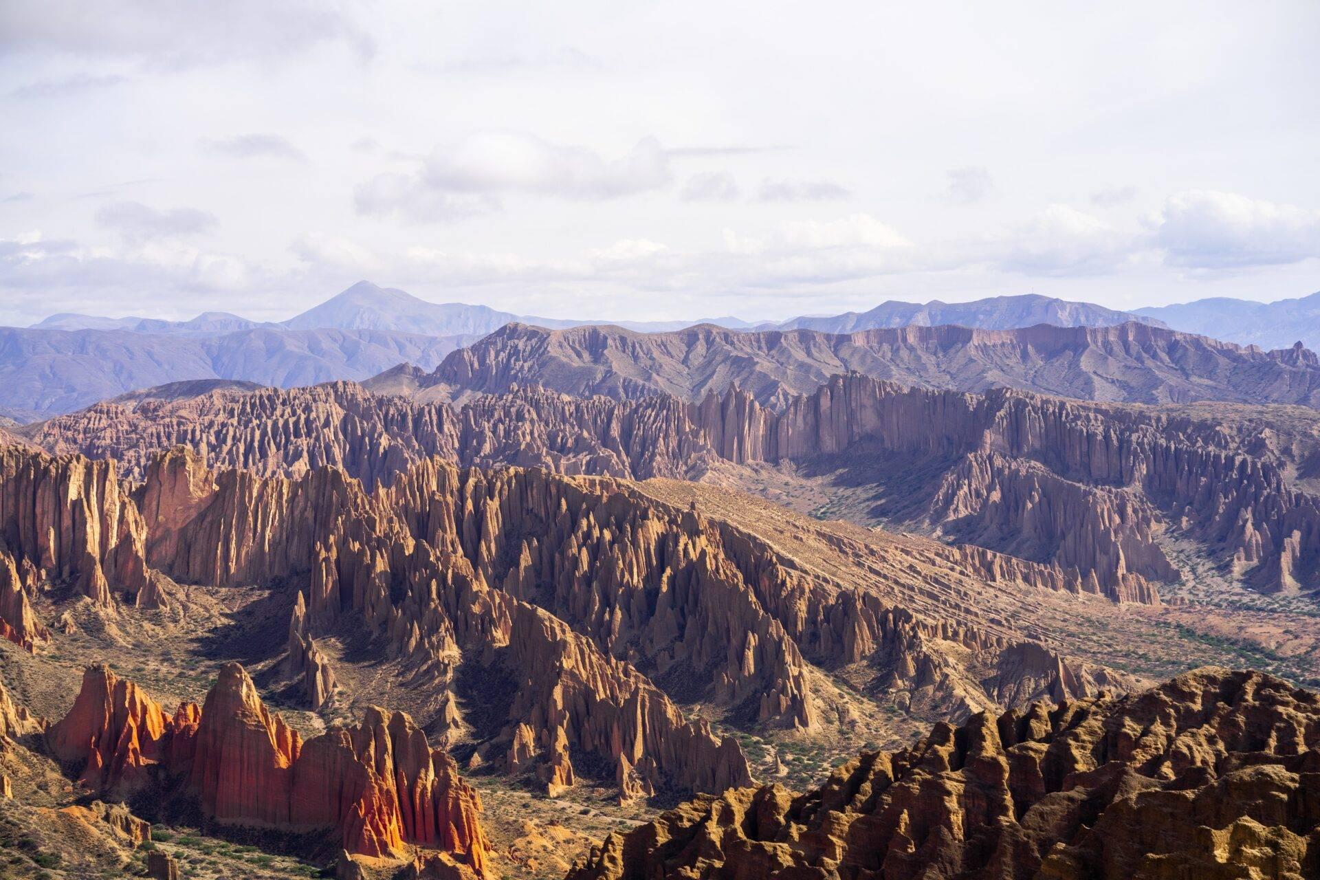 Formations géologiques en colonnes basaltiques dominées par des montagnes sous un ciel nuageux en Bolivie