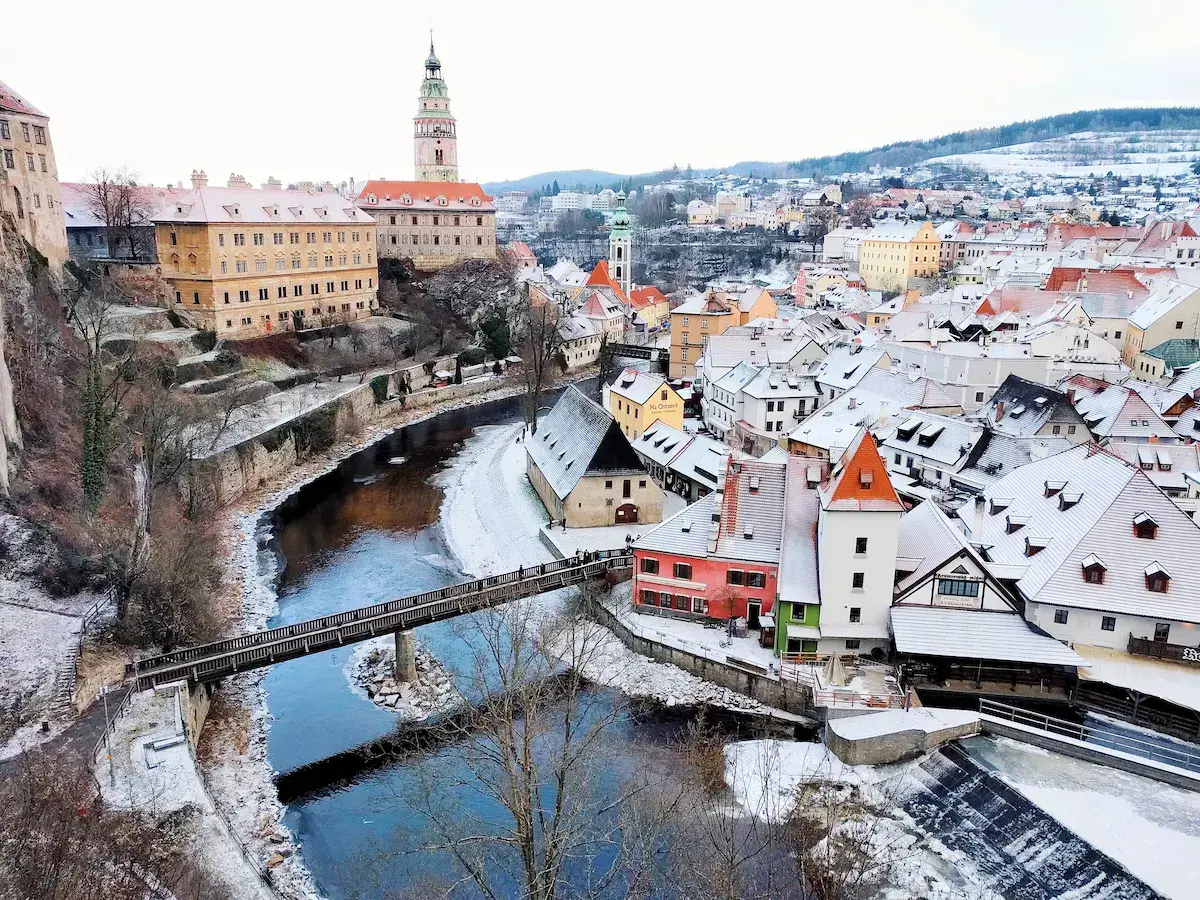 Vue panoramique d’une ville d’Europe centrale avec rivière, château médiéval et toits enneigés en hiver
