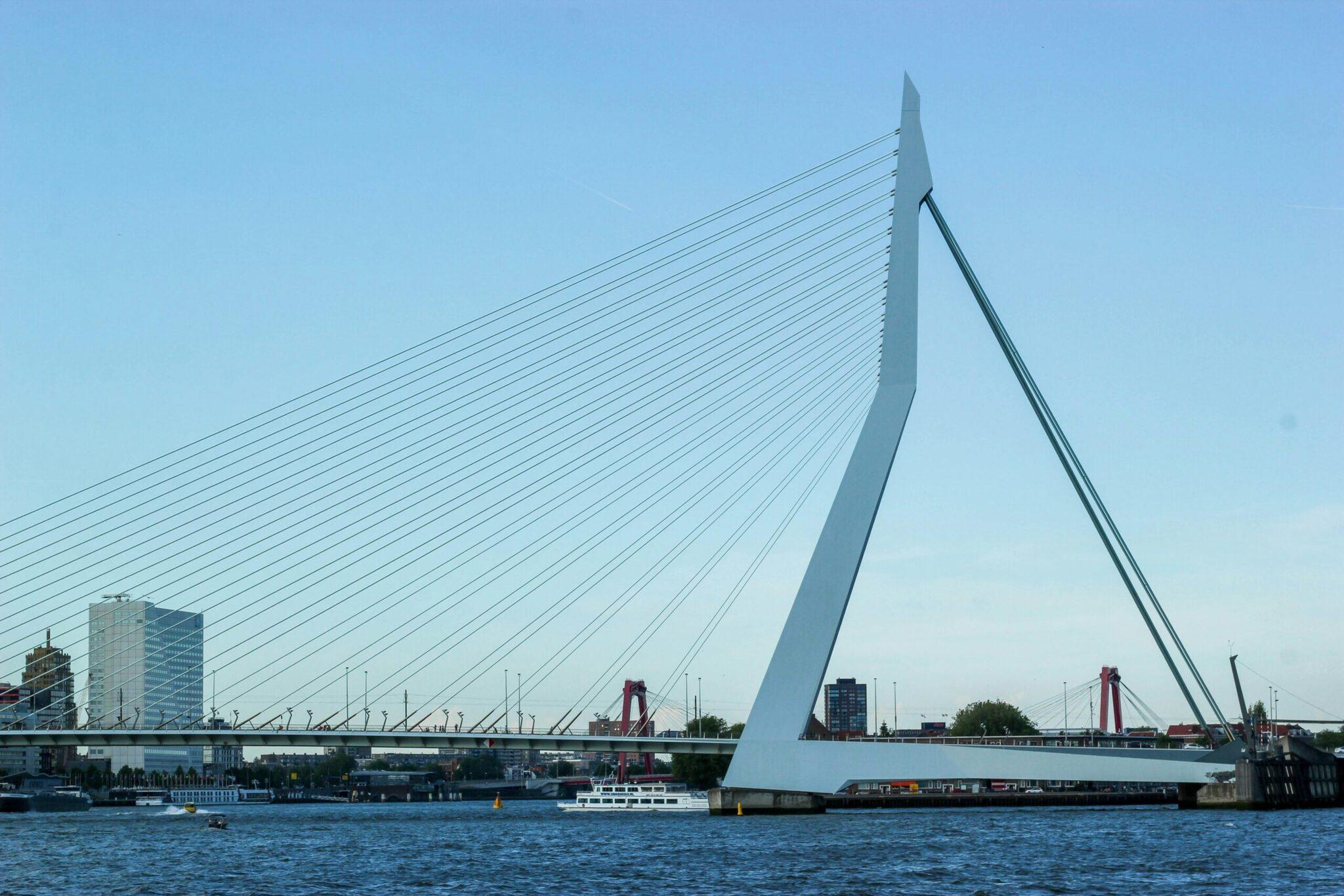 Un pont blanc moderne à haubans enjambant une rivière urbaine par temps dégagé