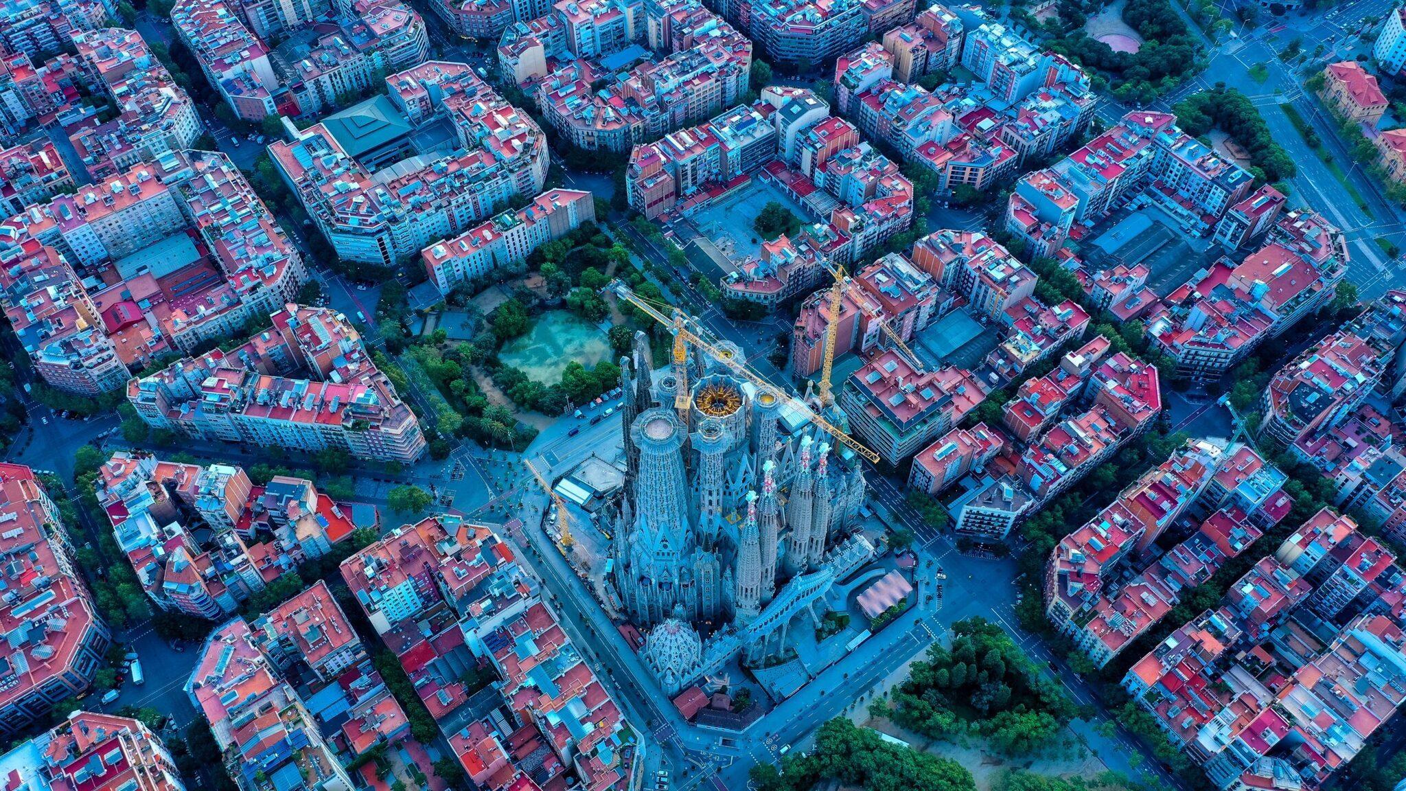 Vue aérienne de la Sagrada Família entourée de bâtiments résidentiels aux toits rouges dans un centre-ville européen