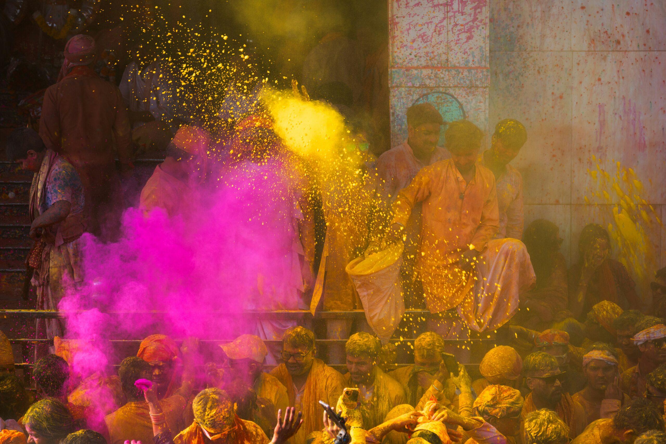 Fête de Holi en Inde, nuages de poudres colorées et foule en liesse sous un ciel bleu