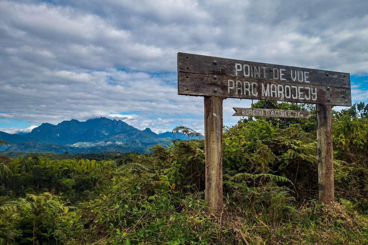 Panneau en bois indiquant un point de vue sur le parc Marojejy, avec vue panoramique sur les montagnes forestières malgaches