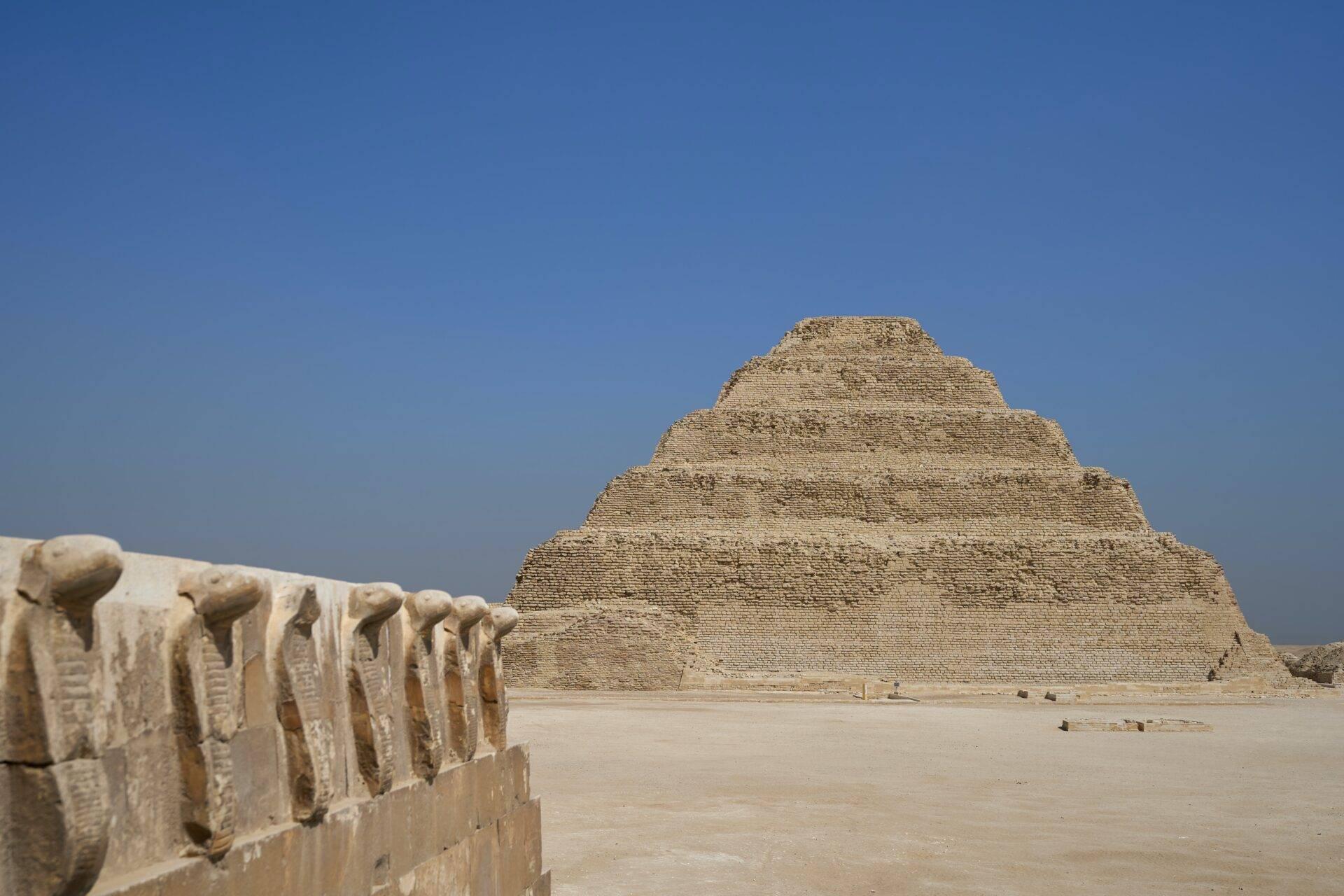 Pyramide à degrés en pierre calcaire dans le désert égyptien avec détails architecturaux au premier plan