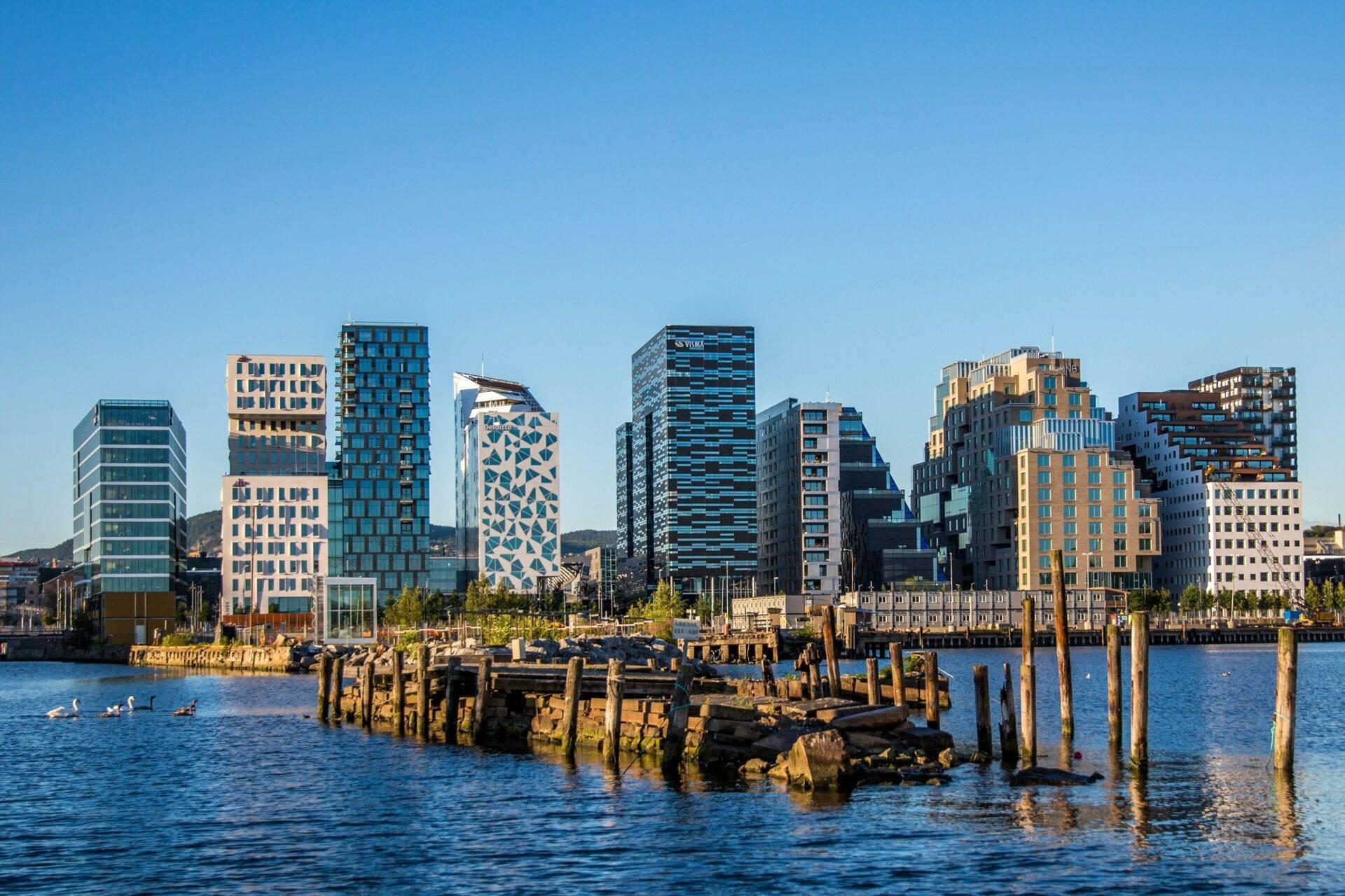 Skyline urbain moderne avec immeubles colorés surplombant un port avec vieux pieux en bois et eau bleue
