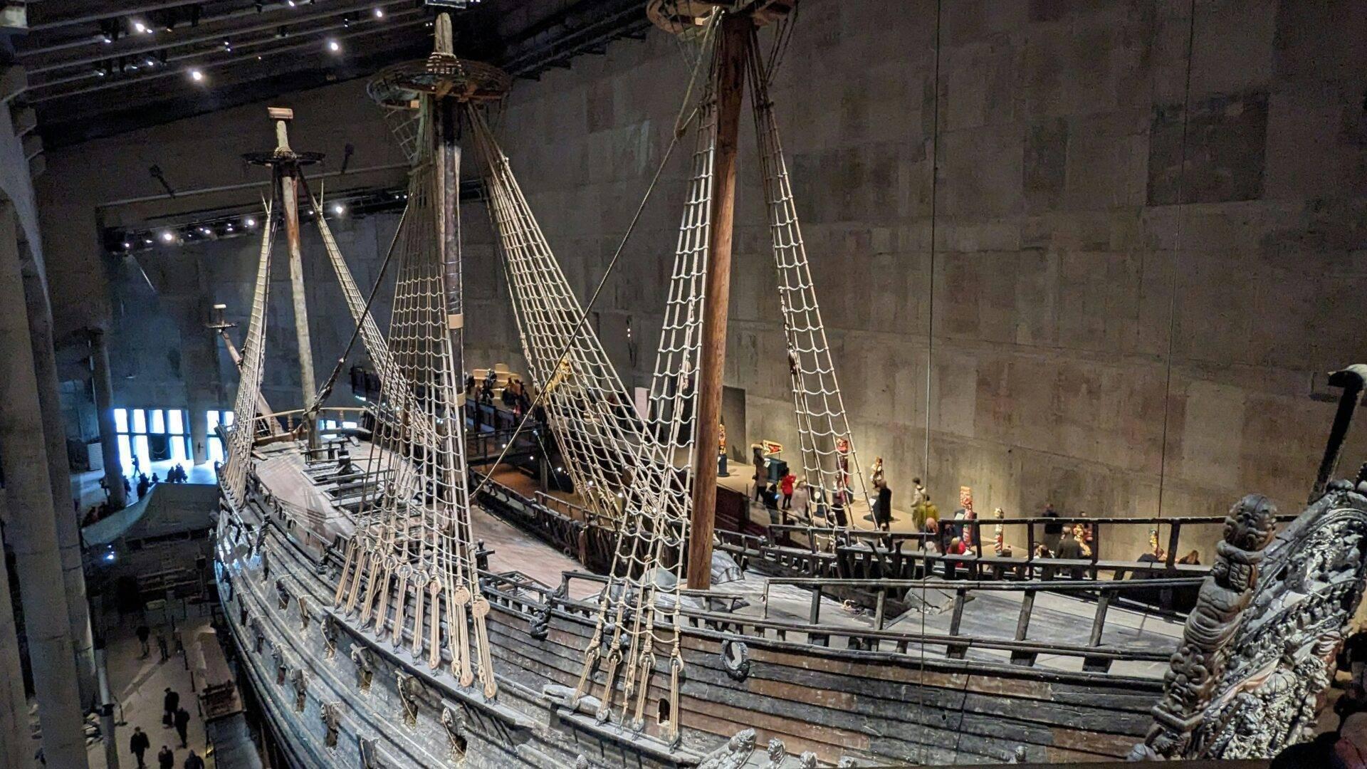 Une galère médiévale préservée dans un musée, avec ses mâts, voiles et cordages intacts, exposée sous éclairage muséal