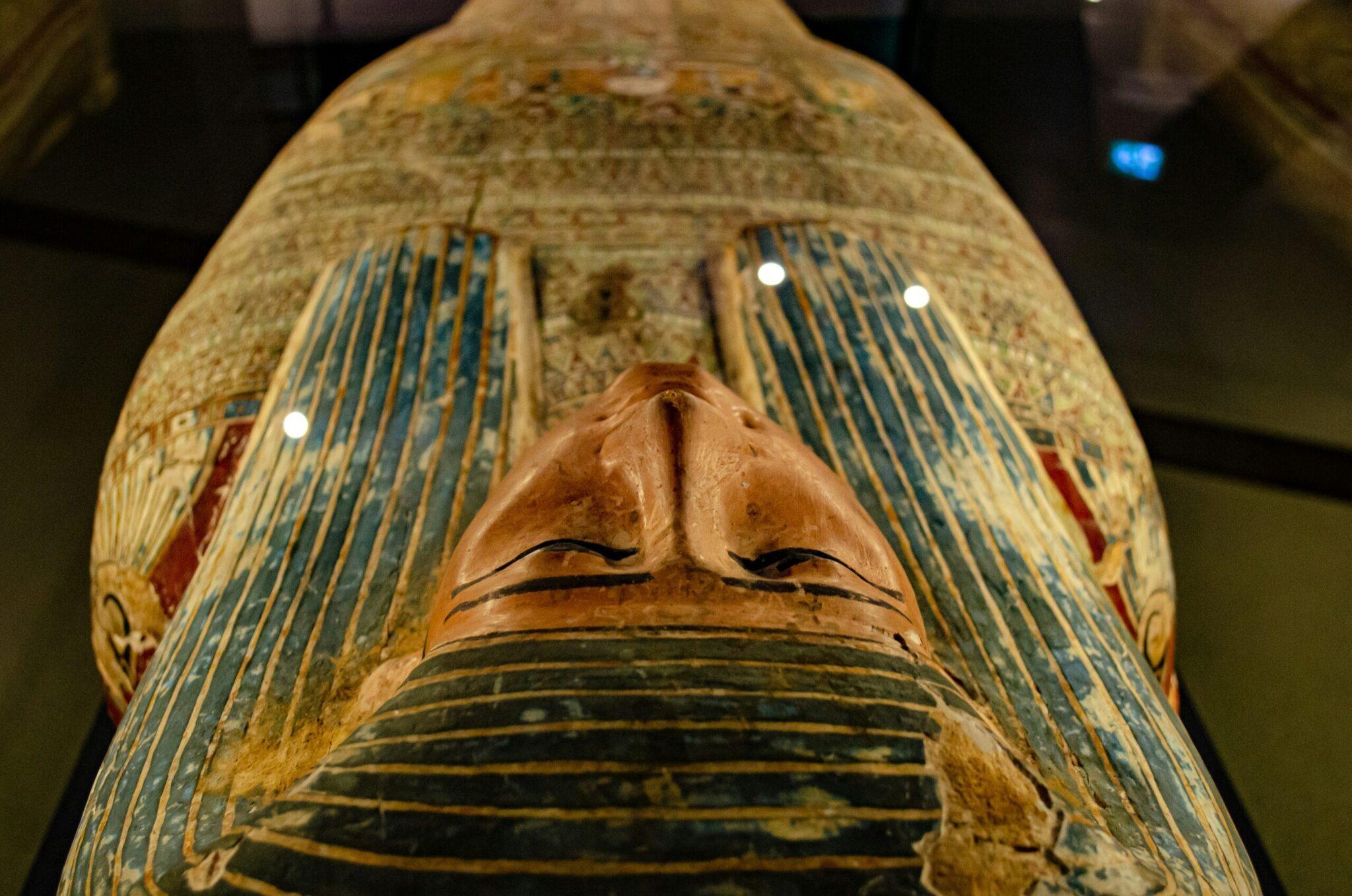 Gros plan sur un sarcophage égyptien momifié avec hiéroglyphes et peintures colorées dans un musée