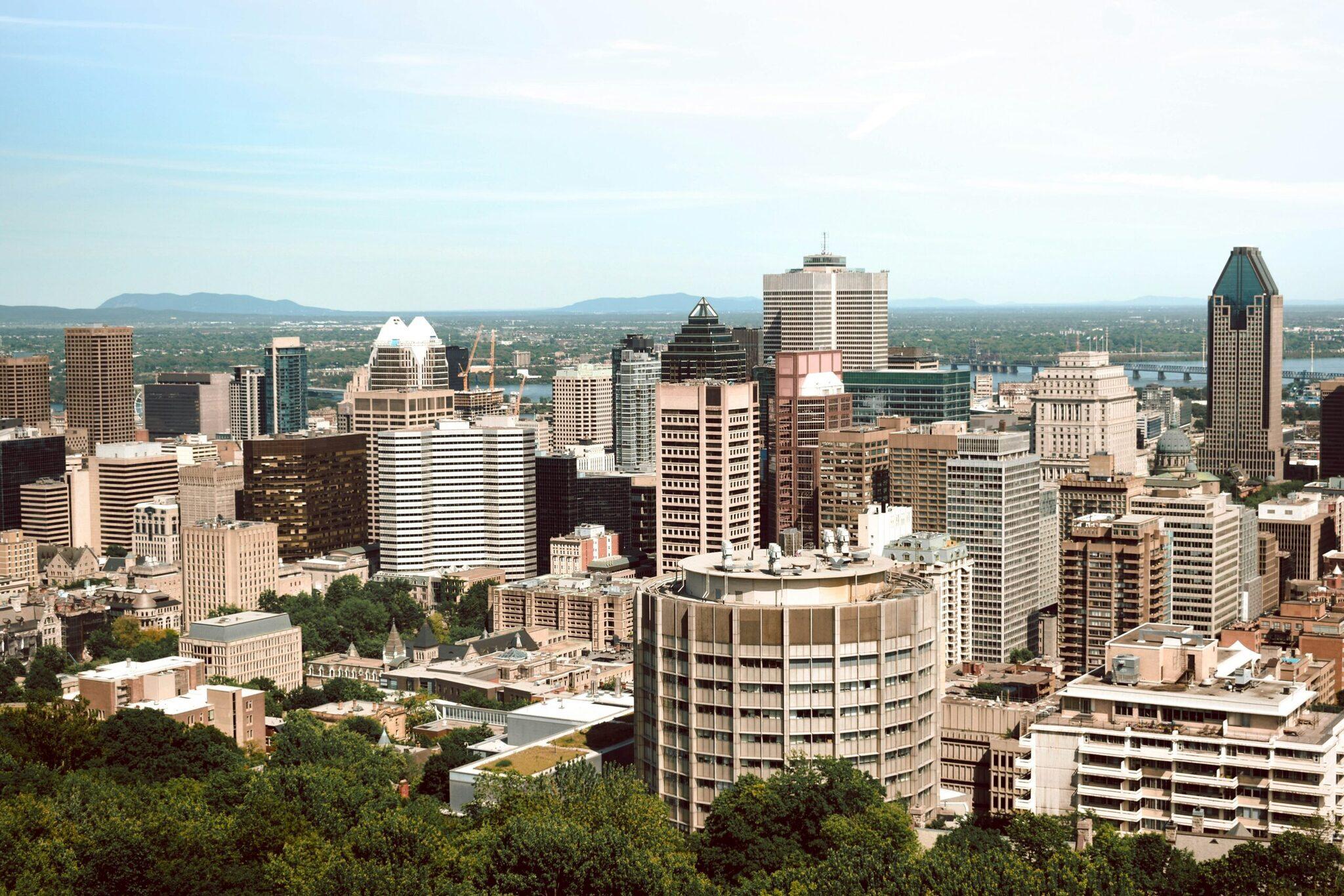 Skyline d’une grande ville nord-américaine avec gratte-ciel modernes, fleuve et montagnes en arrière-plan par temps clair