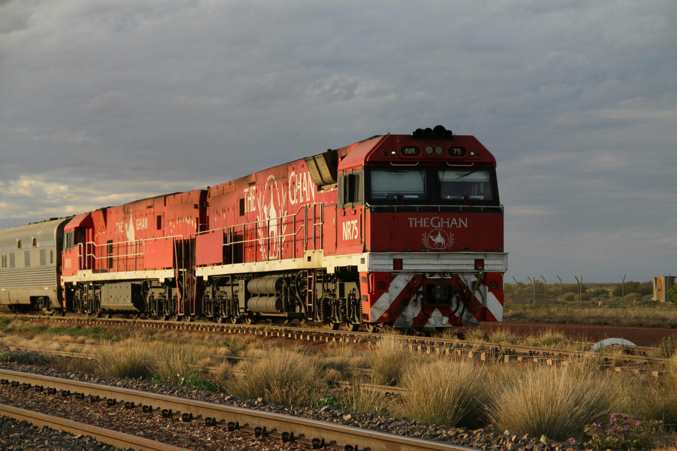 Le Ghan traversant les plaines rouges et arides du Red Centre australien sous un vaste ciel bleu