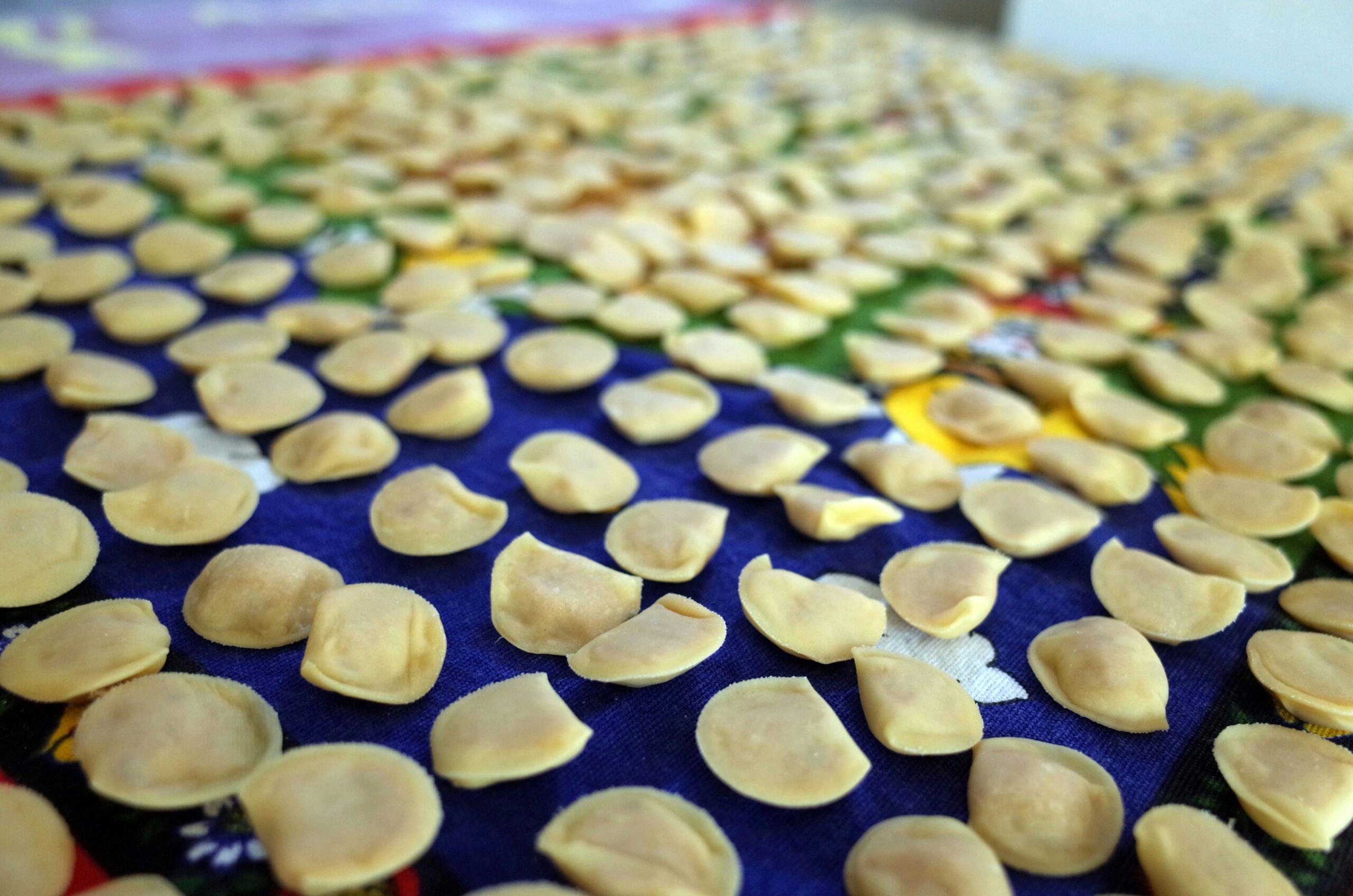 Des amandes effilées blanchies séchant sur des tissus colorés, illustrant la production artisanale de spécialités régionales italiennes